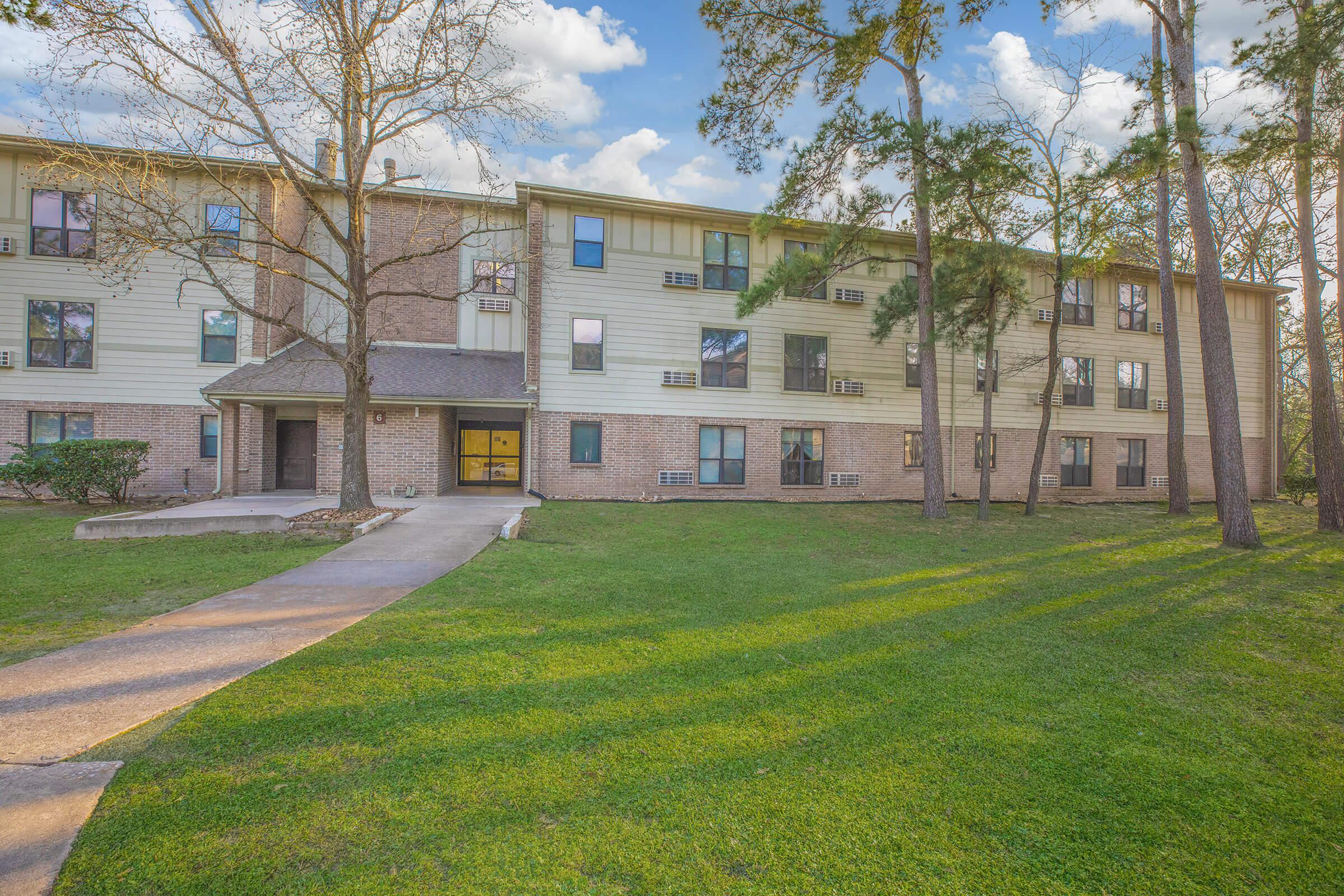 Pineview at Grogansmill community building with green grass and trees