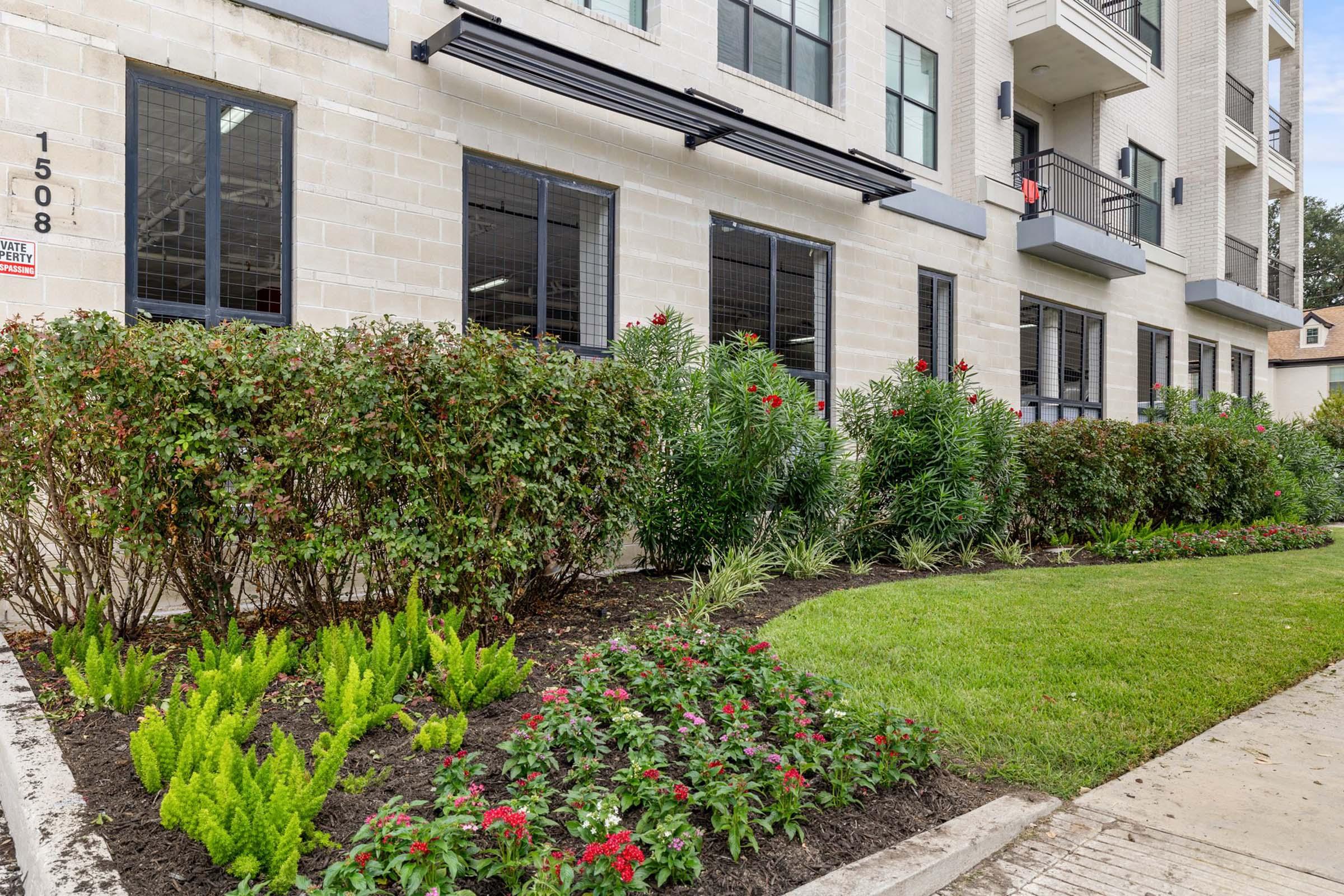 a garden in front of a brick building