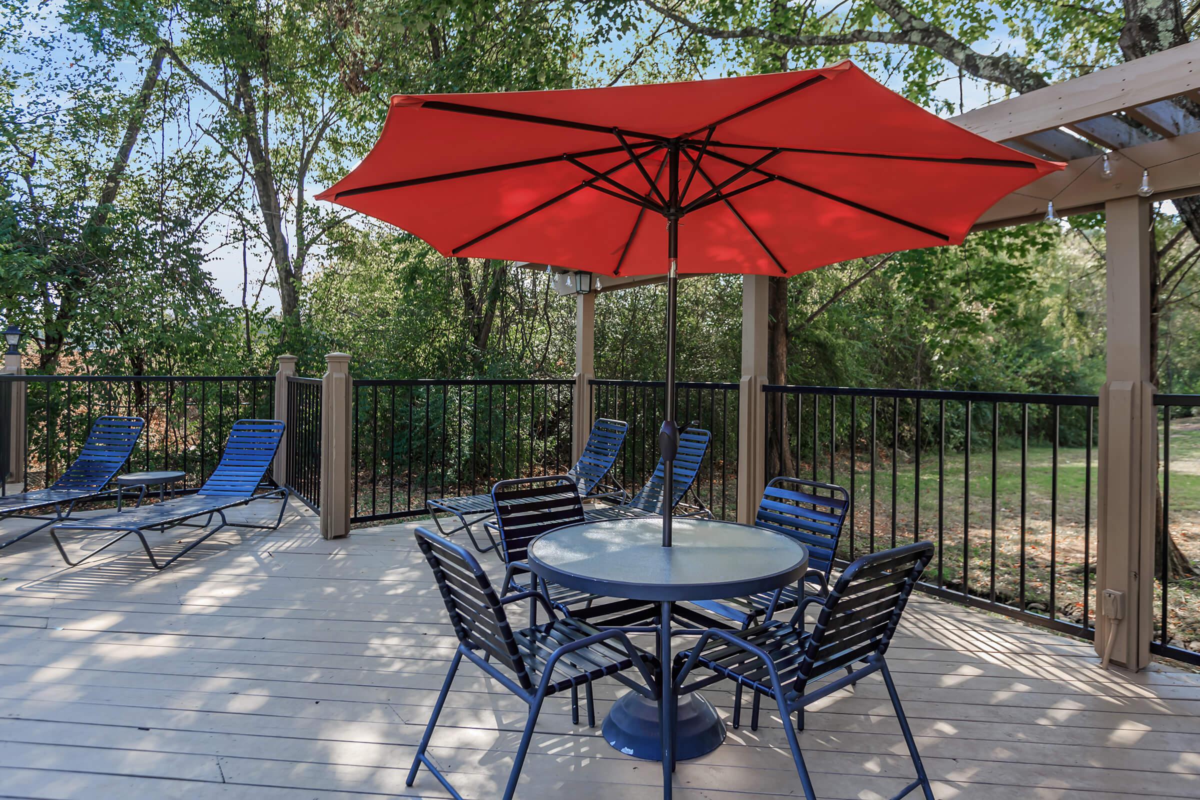 Patio table with umbrella and chaise lounges at Laurel Ridge Apartments in Chattanooga, TN