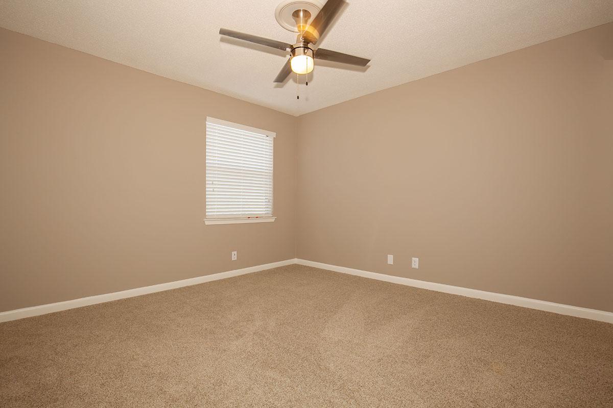 Spacious Bedroom with Ceiling Fan and Plush Carpeting