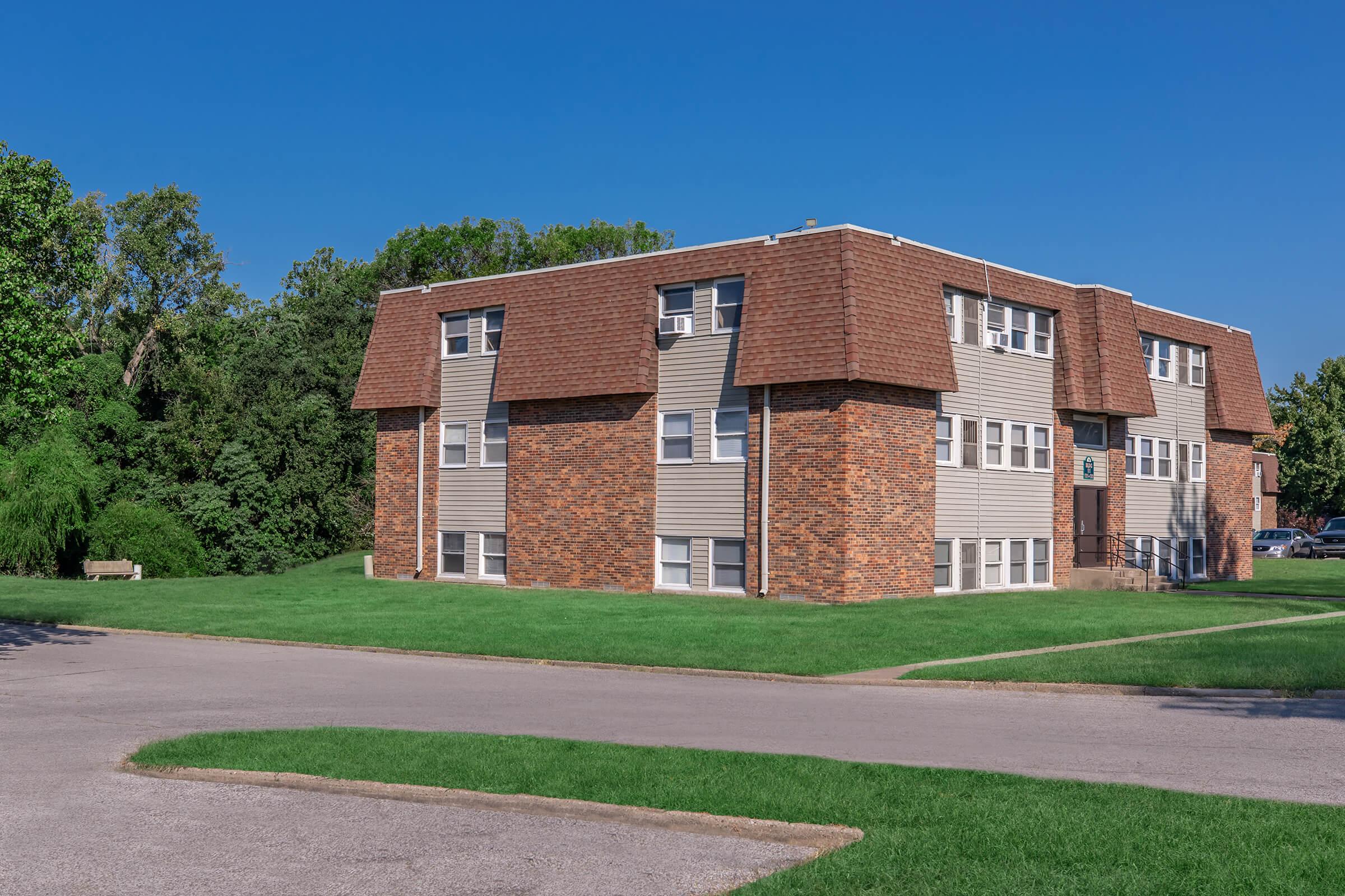 a large brick building with grass in front of a house with US Grant Boyhood Home in the background