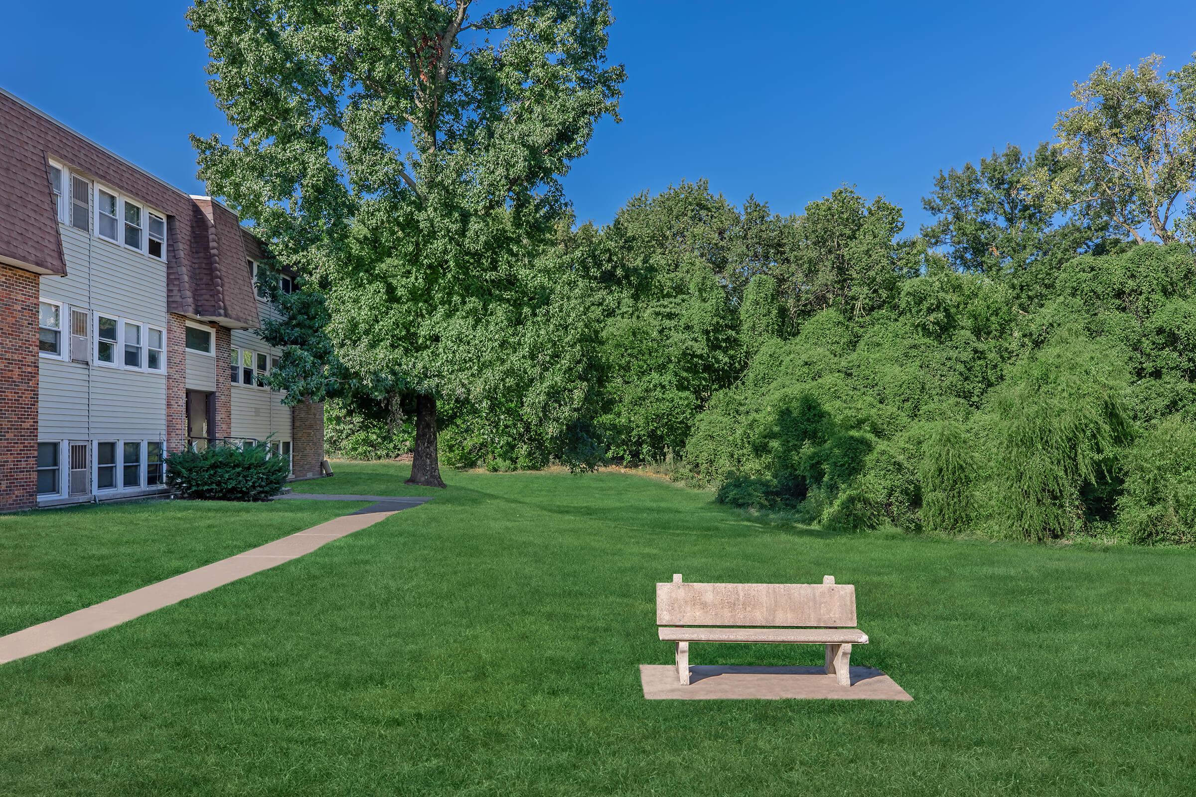 a green park bench sitting in front of a brick building