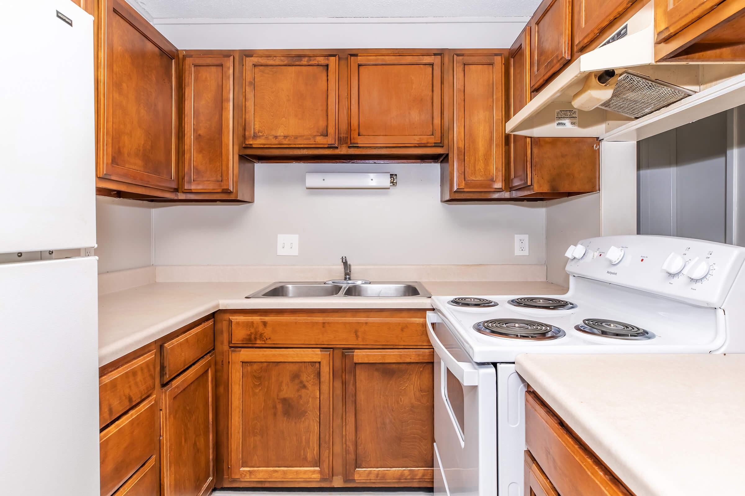 a kitchen with a stove refrigerator and wooden cabinets