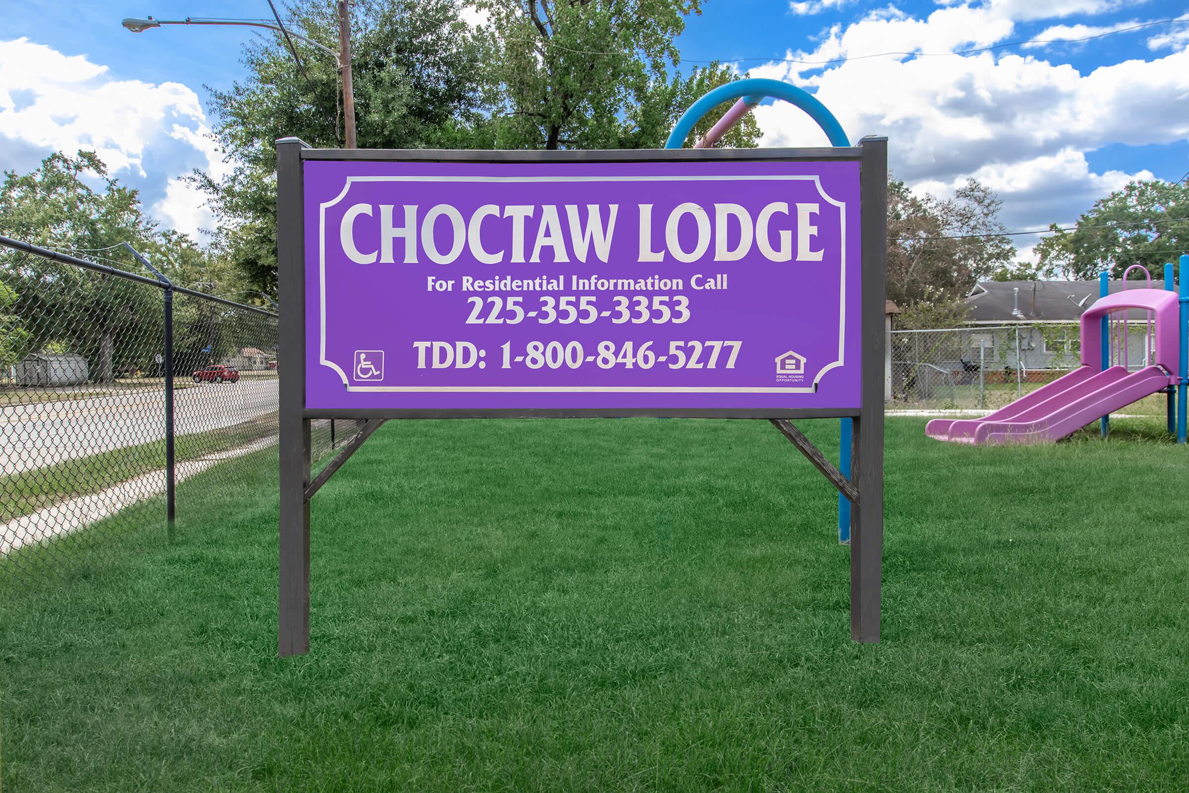 a sign with purple and green grass