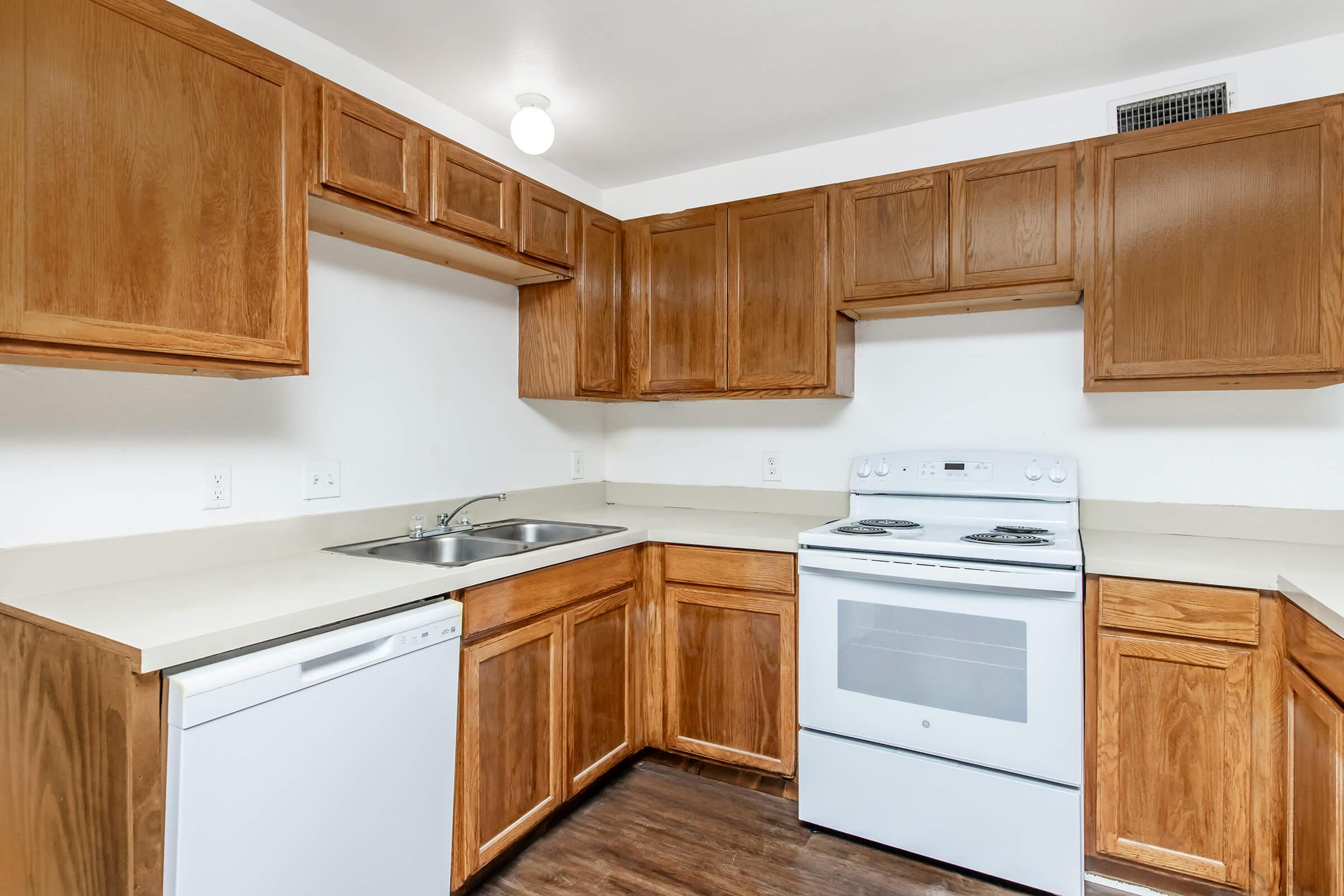 a kitchen with a stove refrigerator and wooden cabinets