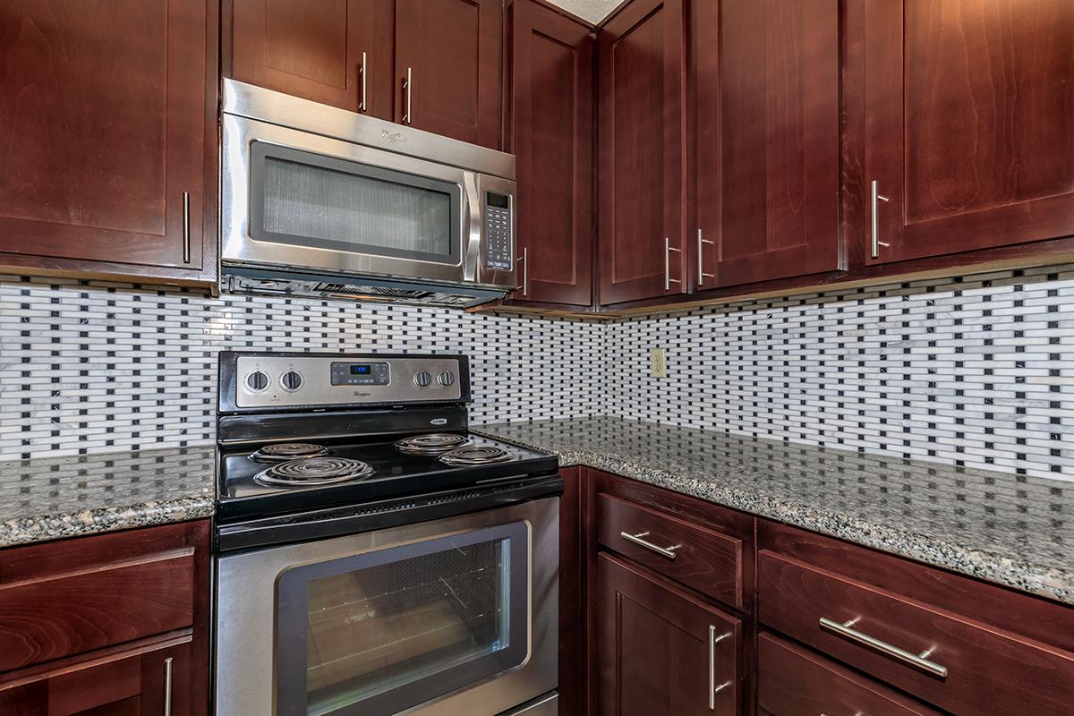 a kitchen with wooden cabinets and a black stove top oven