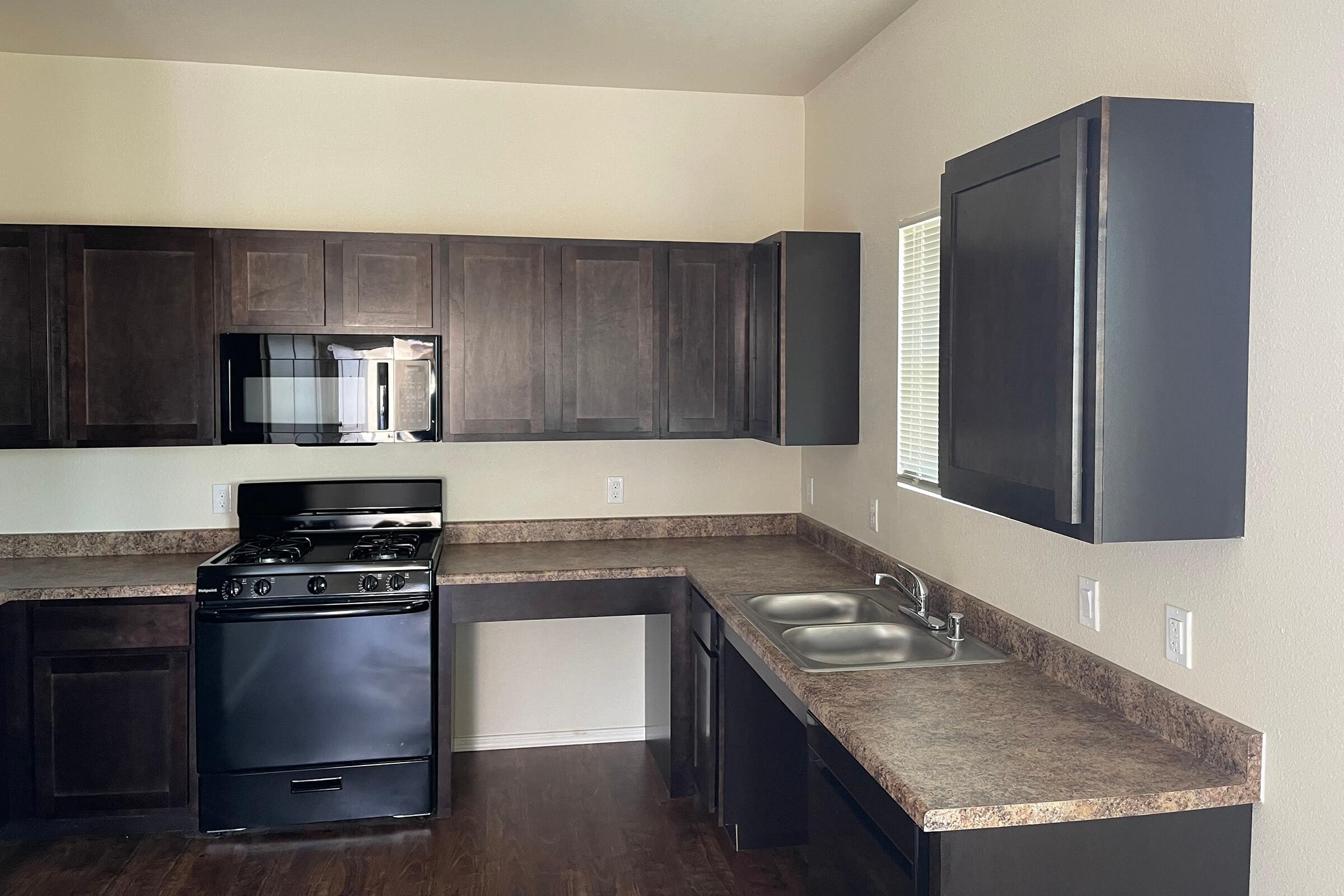 a large kitchen with stainless steel appliances and wooden cabinets