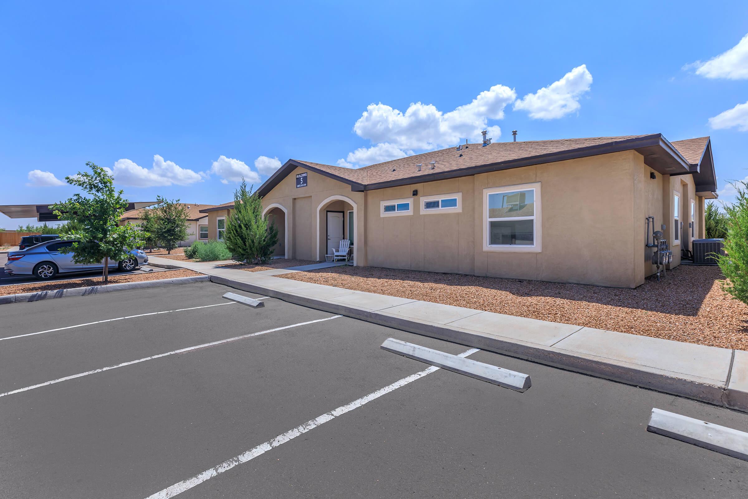 an empty parking lot in front of a house