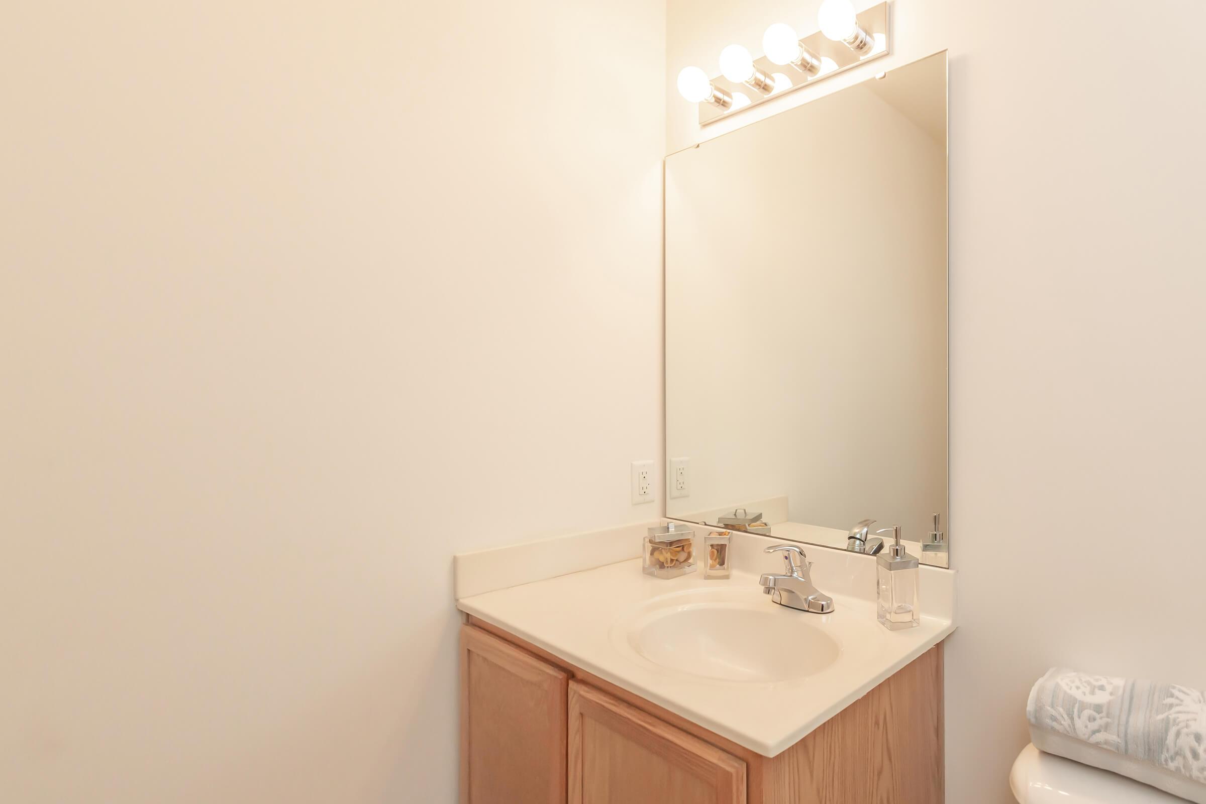 a white sink sitting under a mirror