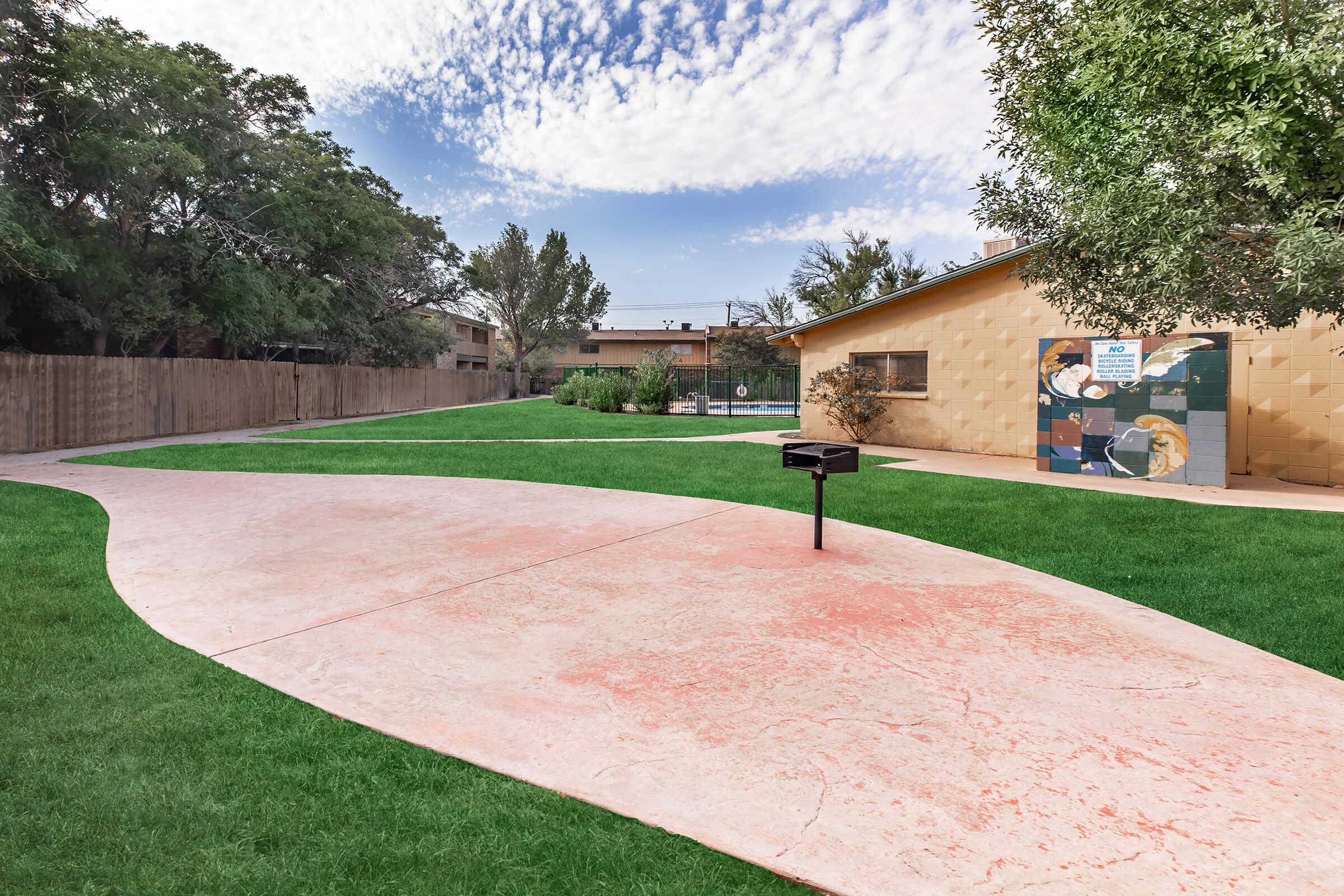 a large lawn in front of a brick wall