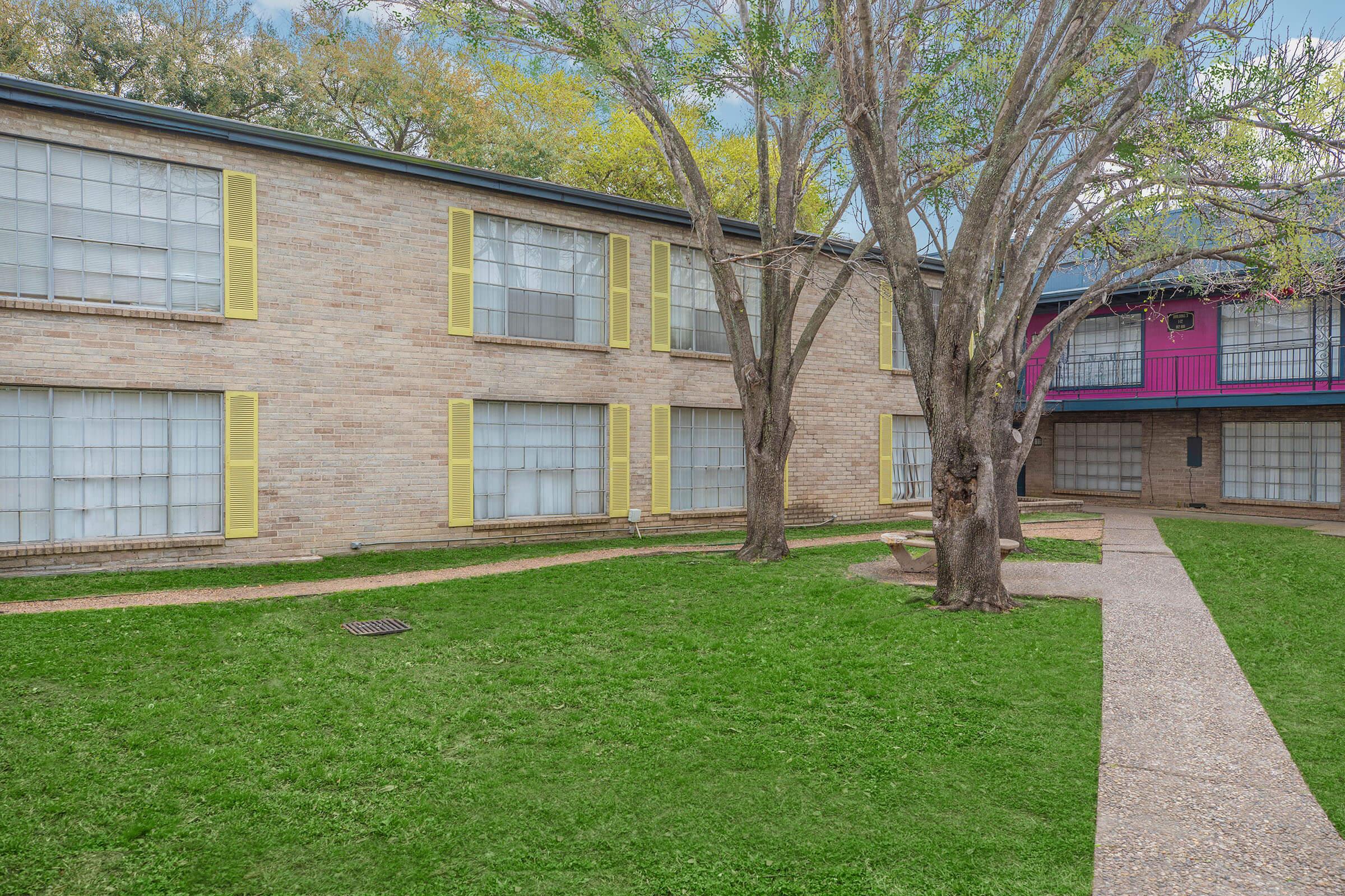 a large lawn in front of a brick building