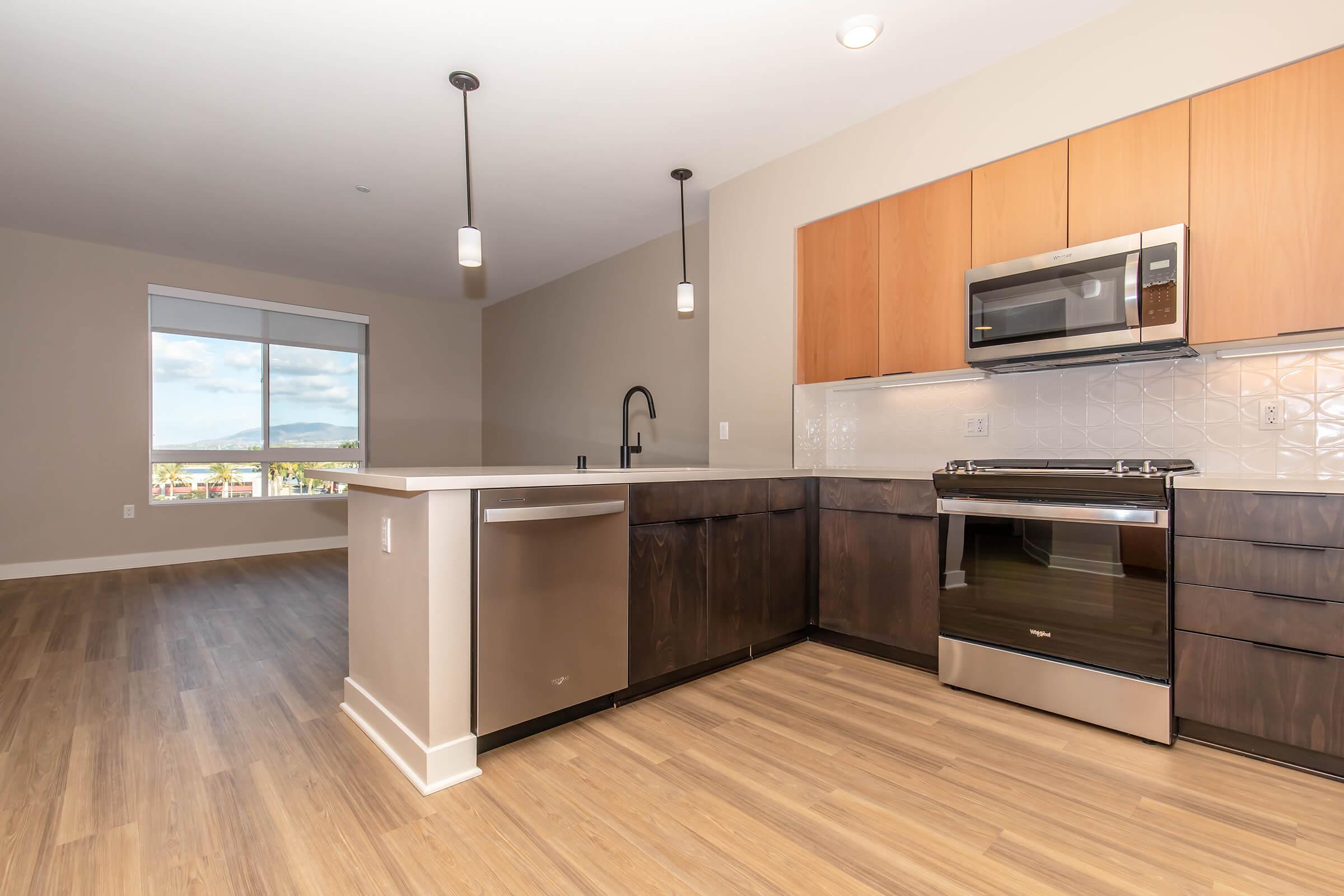 a modern kitchen with stainless steel appliances and wooden cabinets