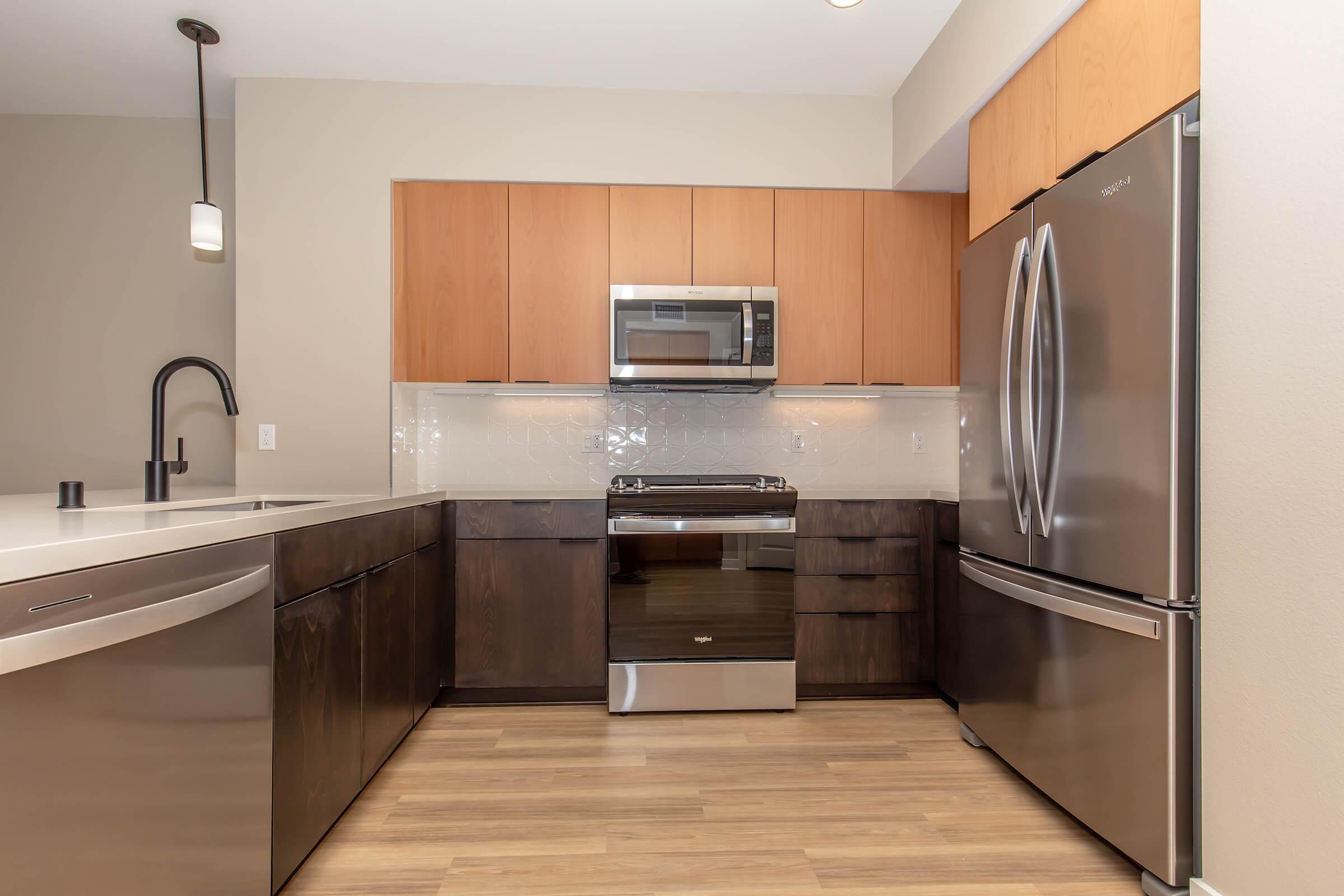 a modern kitchen with stainless steel appliances and wooden cabinets