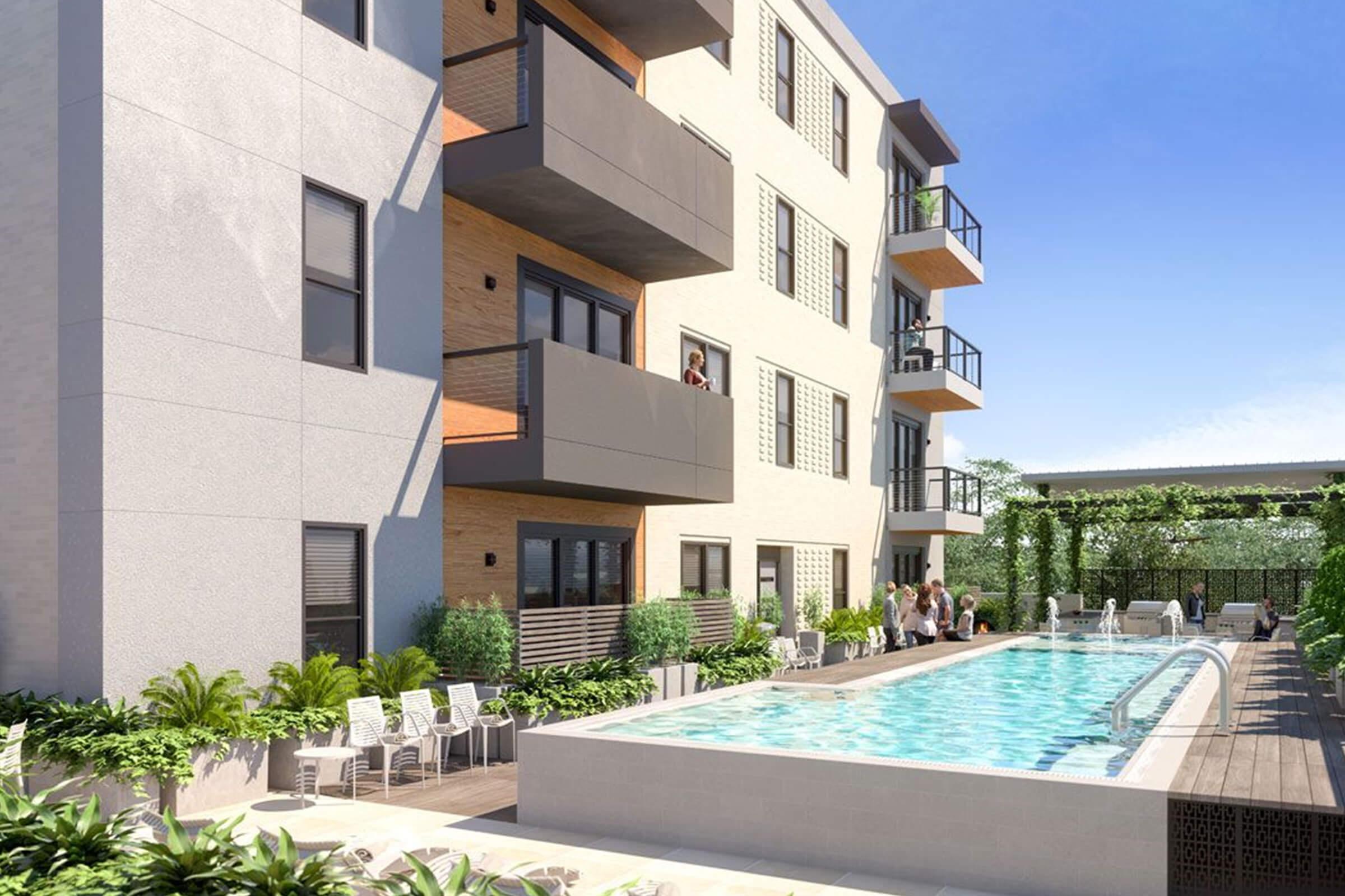 A modern apartment complex featuring a sunny courtyard with a swimming pool. Balconies with greenery adorn the building's exterior, while residents enjoy the pool area and socialize amidst landscaped surroundings. Clear blue skies enhance the inviting atmosphere.