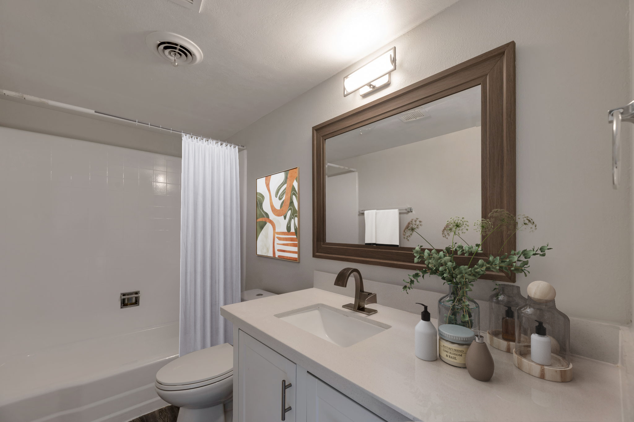 A modern bathroom featuring a white bathtub with a shower curtain, a rectangular mirror above a light-colored vanity, and a decorative painting on the wall. Accessories include hand soap and lotion on the counter, with plants adding a touch of greenery to the space.