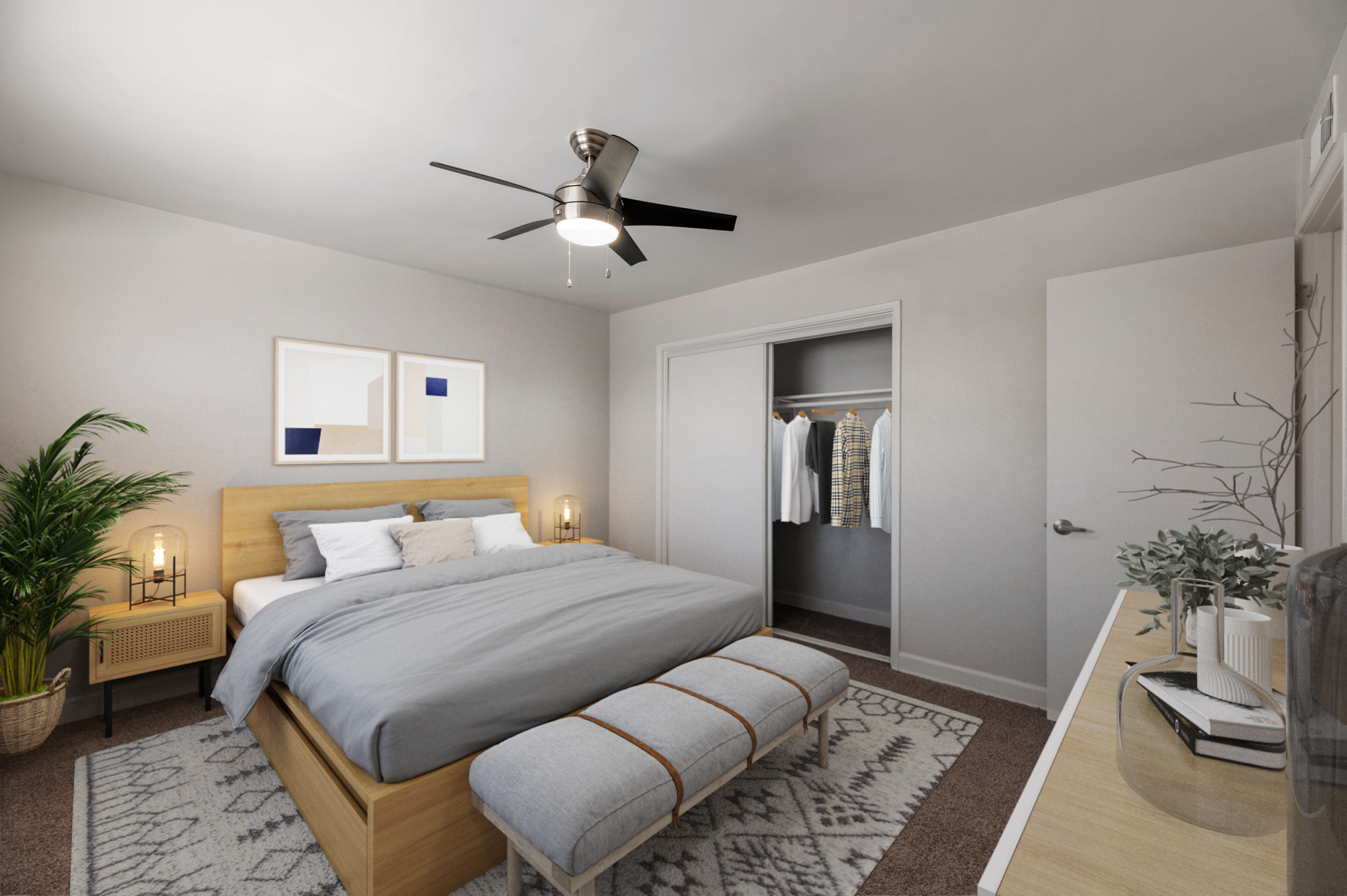 A modern bedroom featuring a wooden bed with gray bedding, a light gray bench at the foot, and minimalistic decor. There are two framed artworks on the wall, a potted plant in the corner, and a closet with neatly hung clothes. A ceiling fan with a light fixture is also visible.