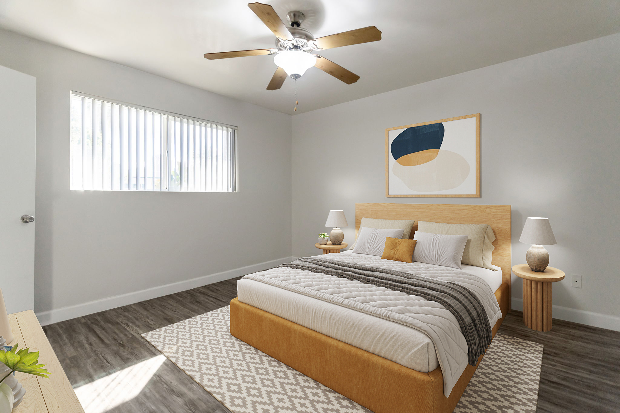 A modern bedroom featuring a queen-sized bed with a beige and gray comforter, wooden nightstands, and lamps. A large wall art piece is above the bed, and there are sliding window blinds allowing natural light in. The floor is covered with a patterned rug, and there's a ceiling fan above.
