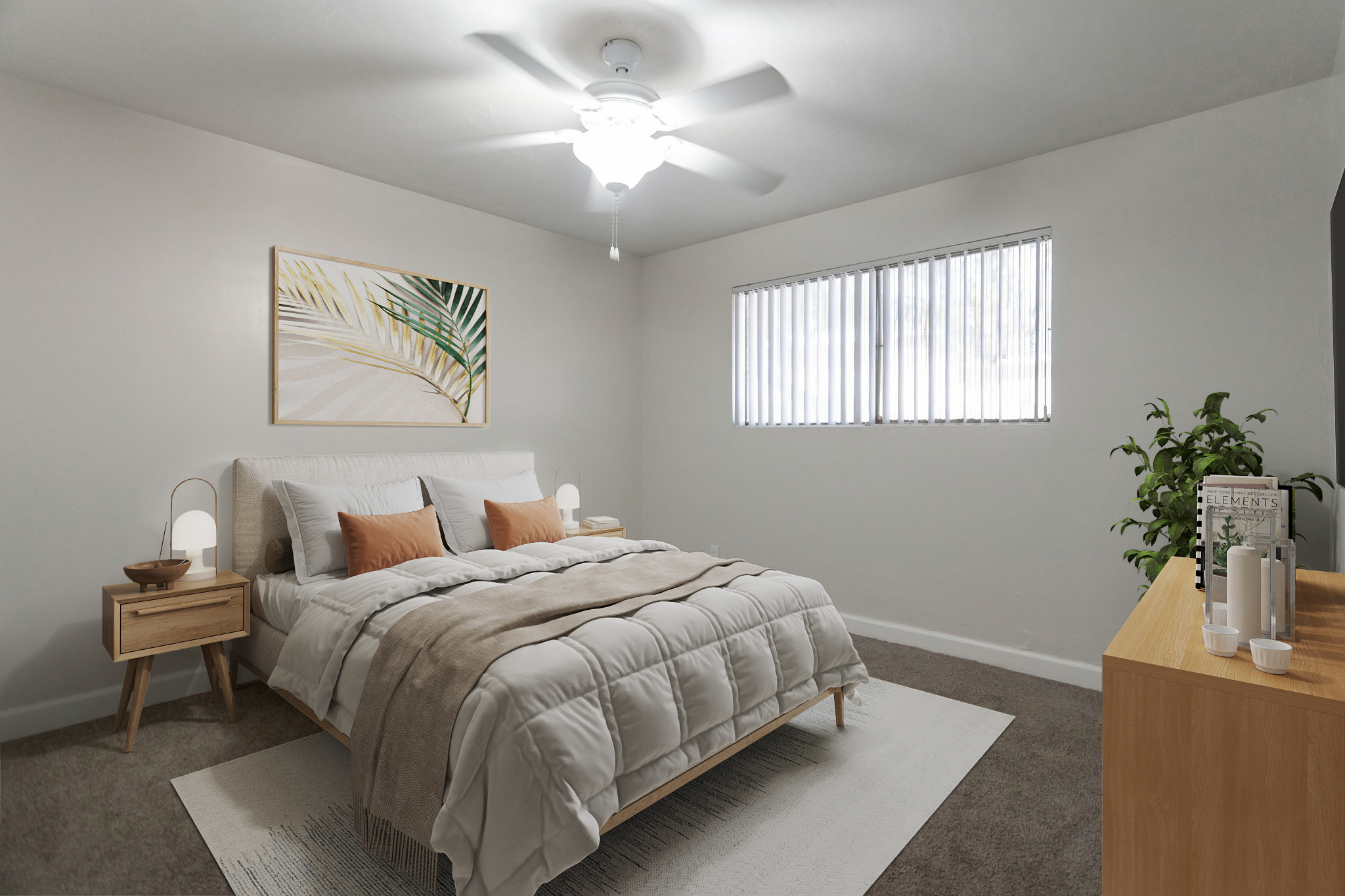A cozy, modern bedroom featuring a queen-sized bed with gray and white bedding, decorative pillows, and a soft throw. The room includes a ceiling fan, two bedside lamps on wooden tables, a large window with vertical blinds, a potted plant in the corner, and a wooden dresser. A piece of wall art with a leaf design adds a touch of decor.