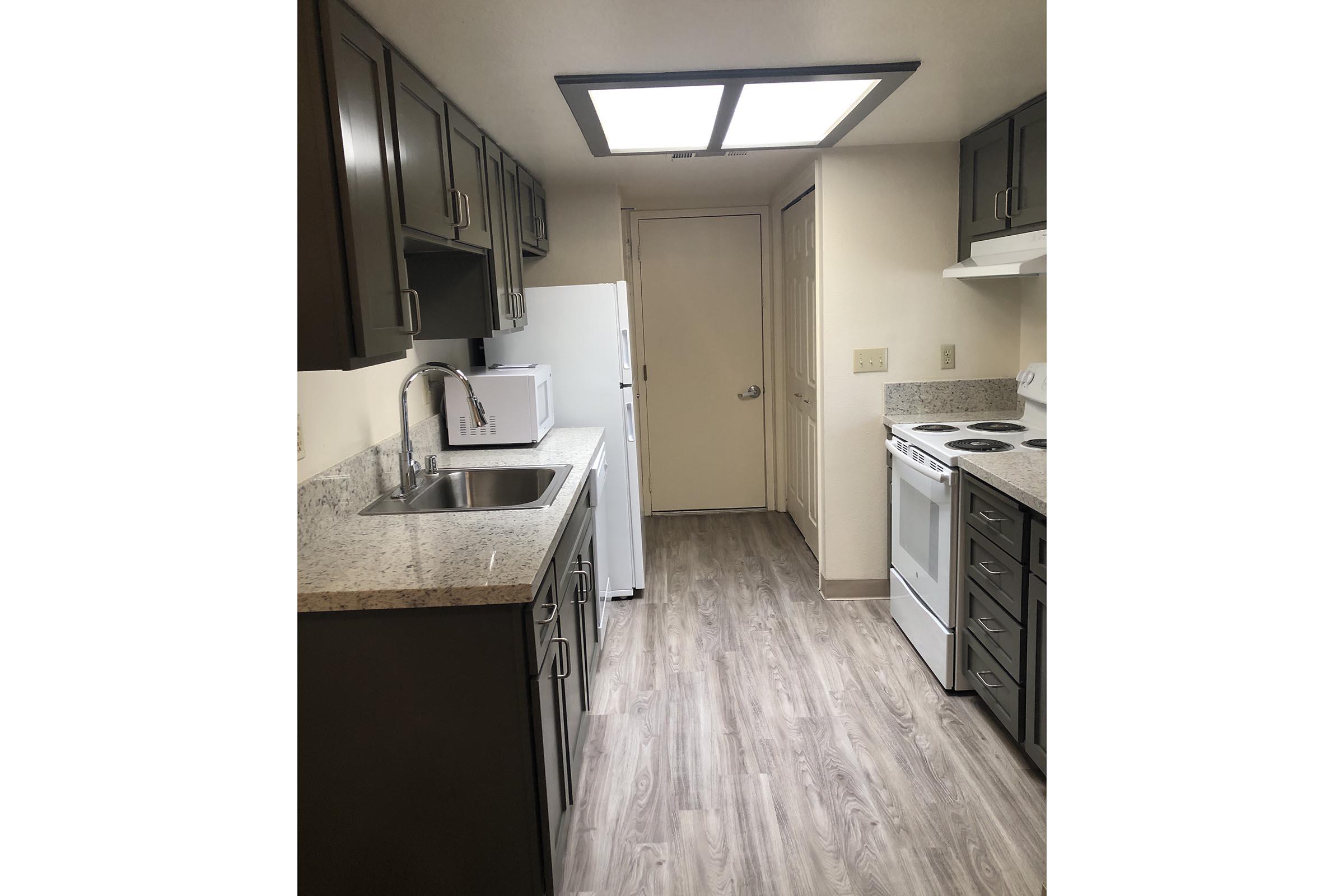 a kitchen with a sink and a mirror