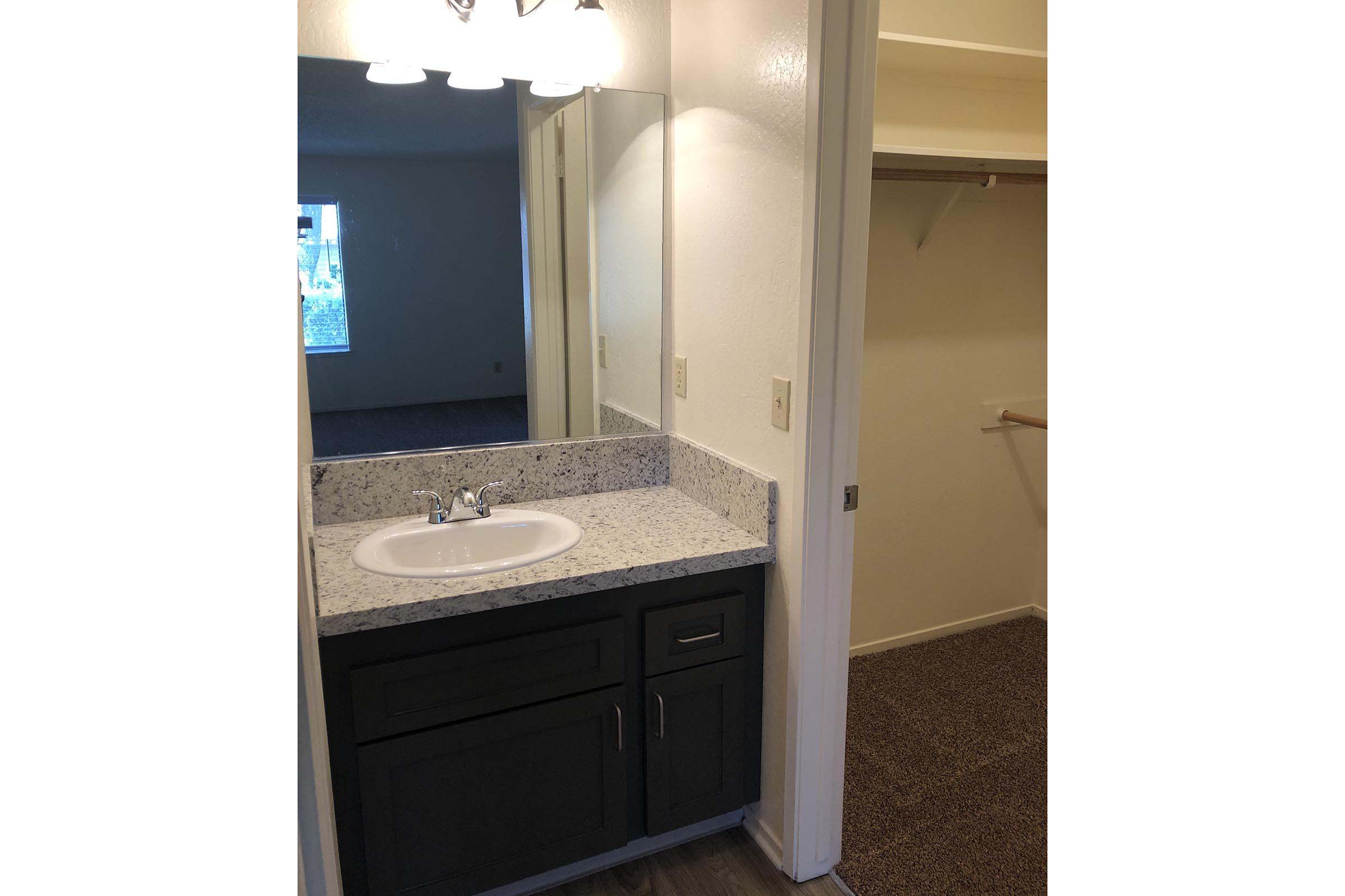 a kitchen with a sink and a mirror