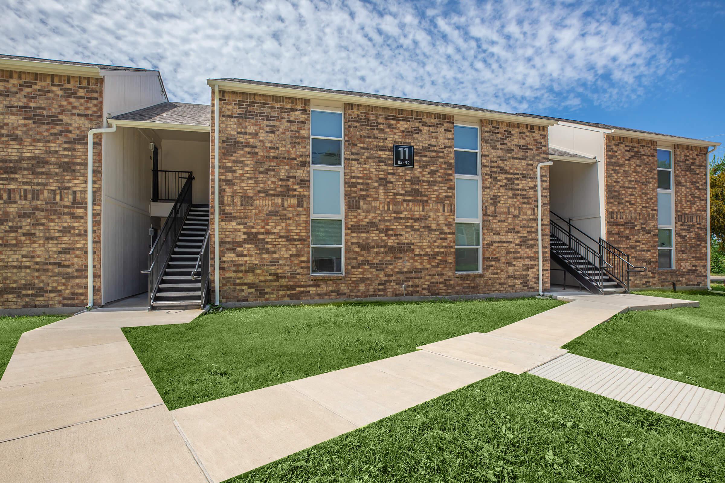 a large lawn in front of a brick building