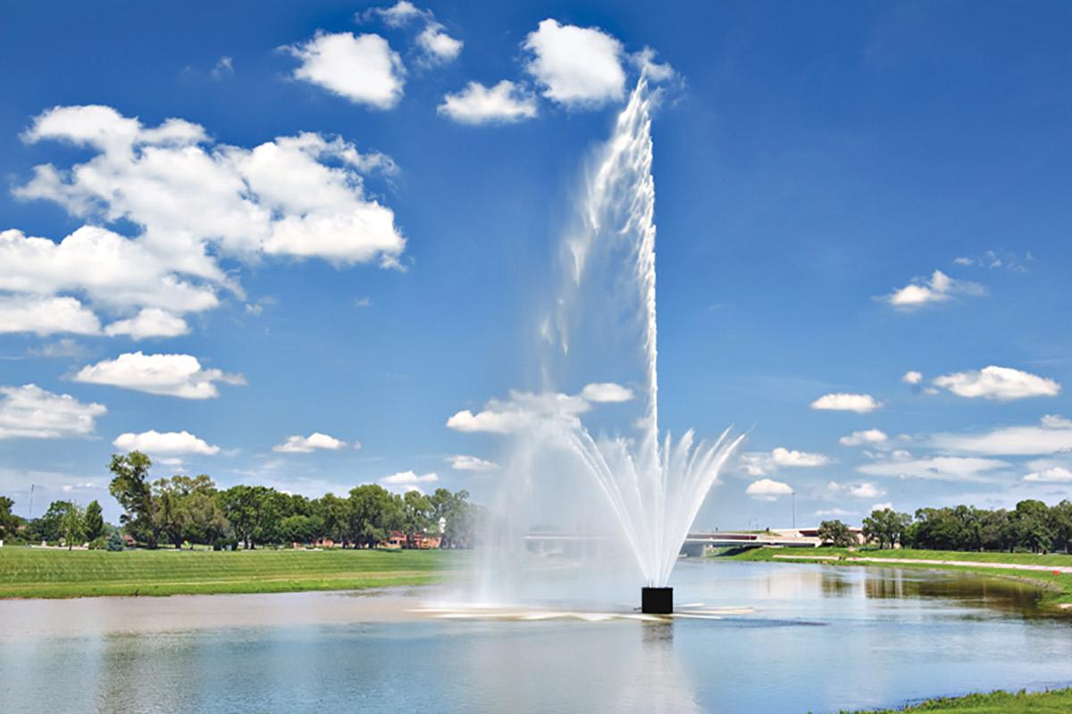 a fountain in front of a body of water