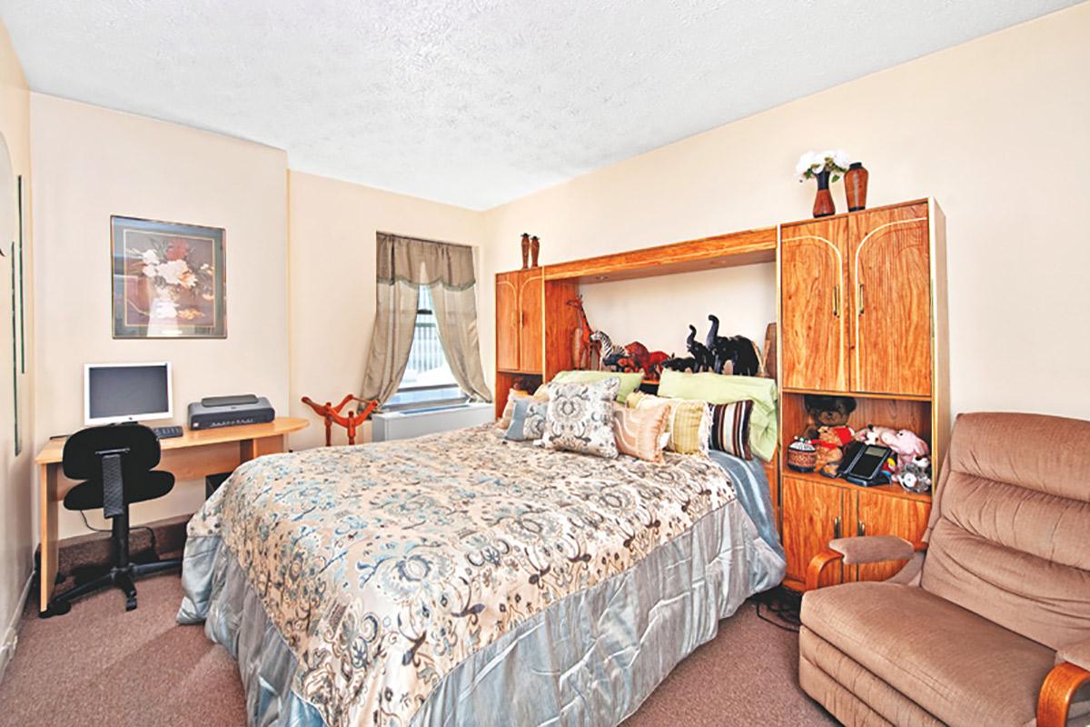 a bedroom with a bed and desk in a room
