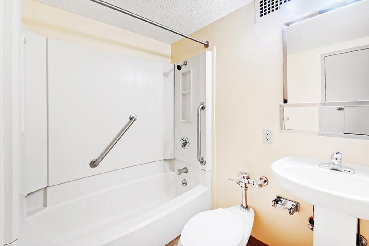 a white sink sitting under a mirror