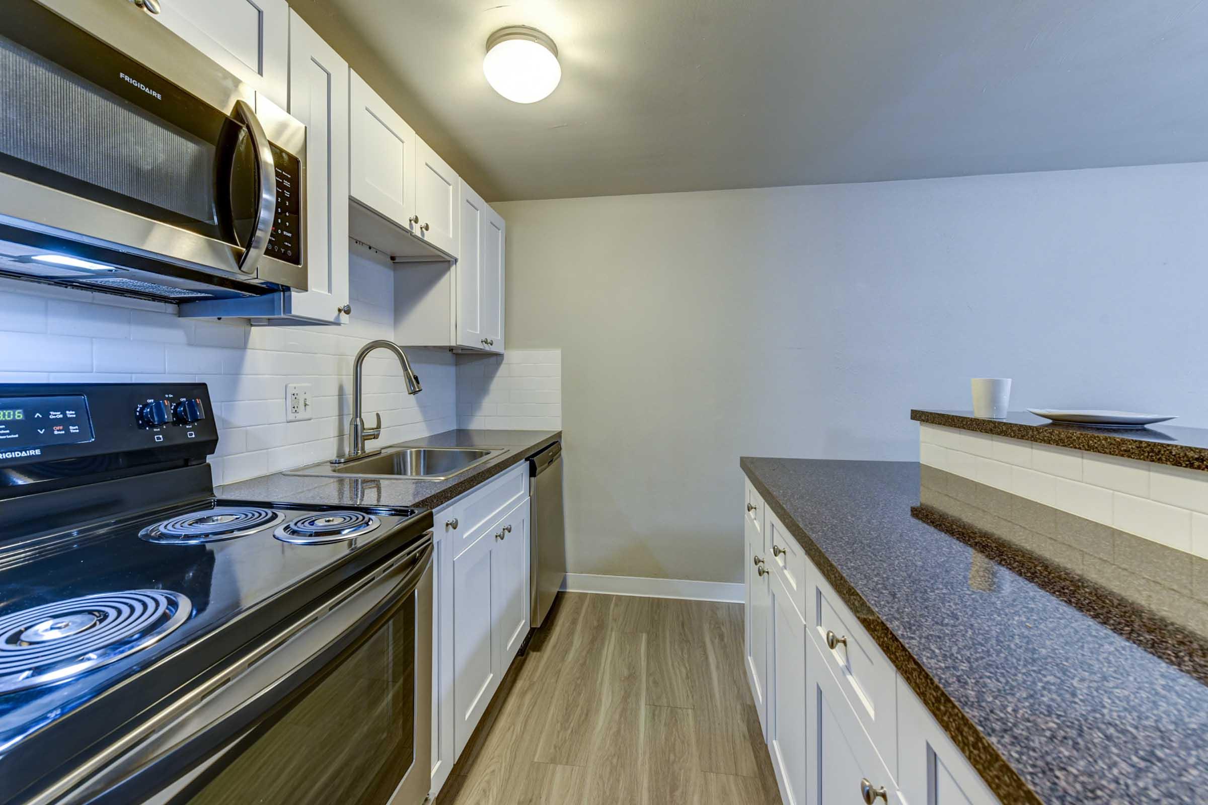 Modern kitchen featuring stainless steel appliances, including an electric range and microwave. 