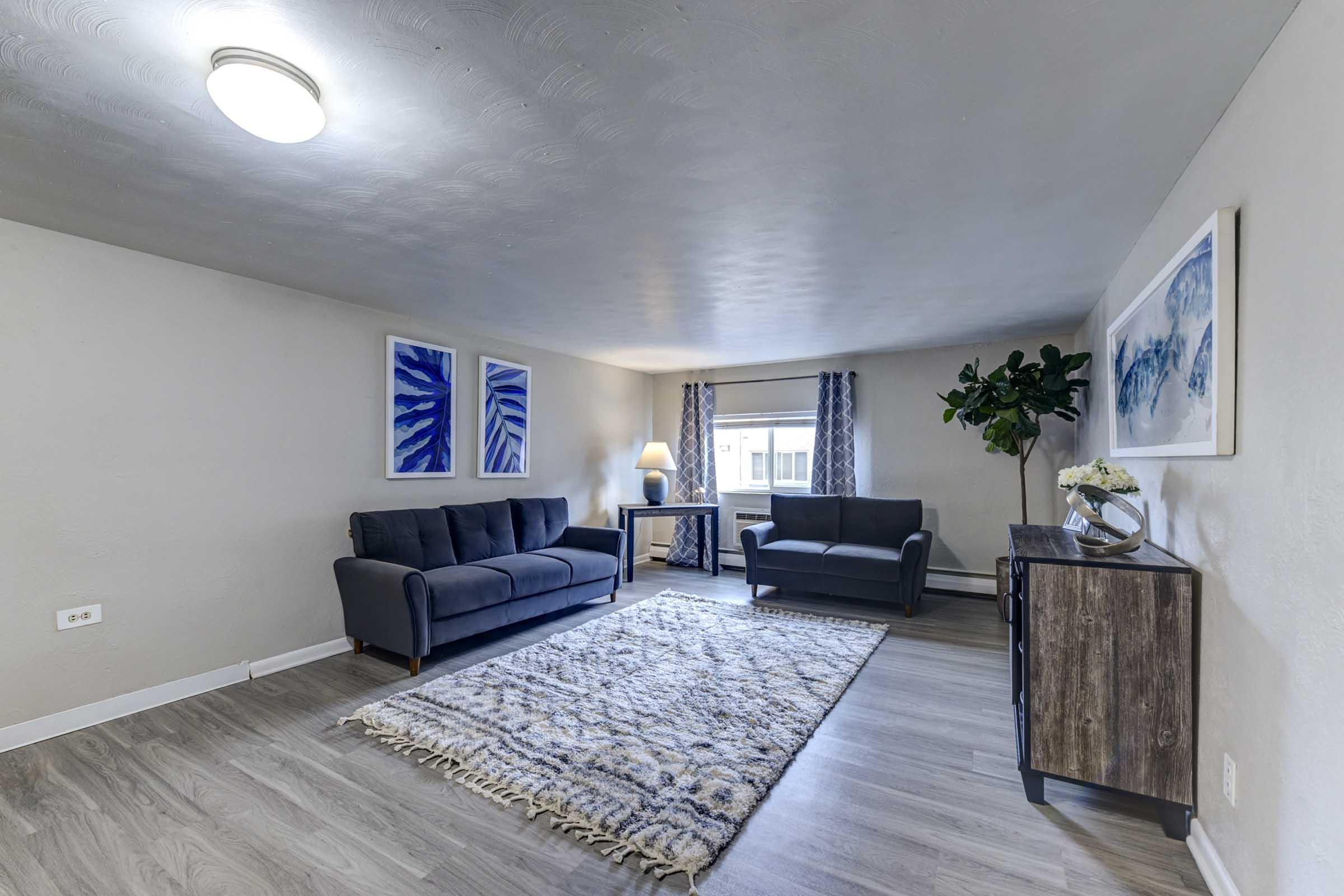  A well-lit modern living room featuring a dark gray sofa and a matching armchair.