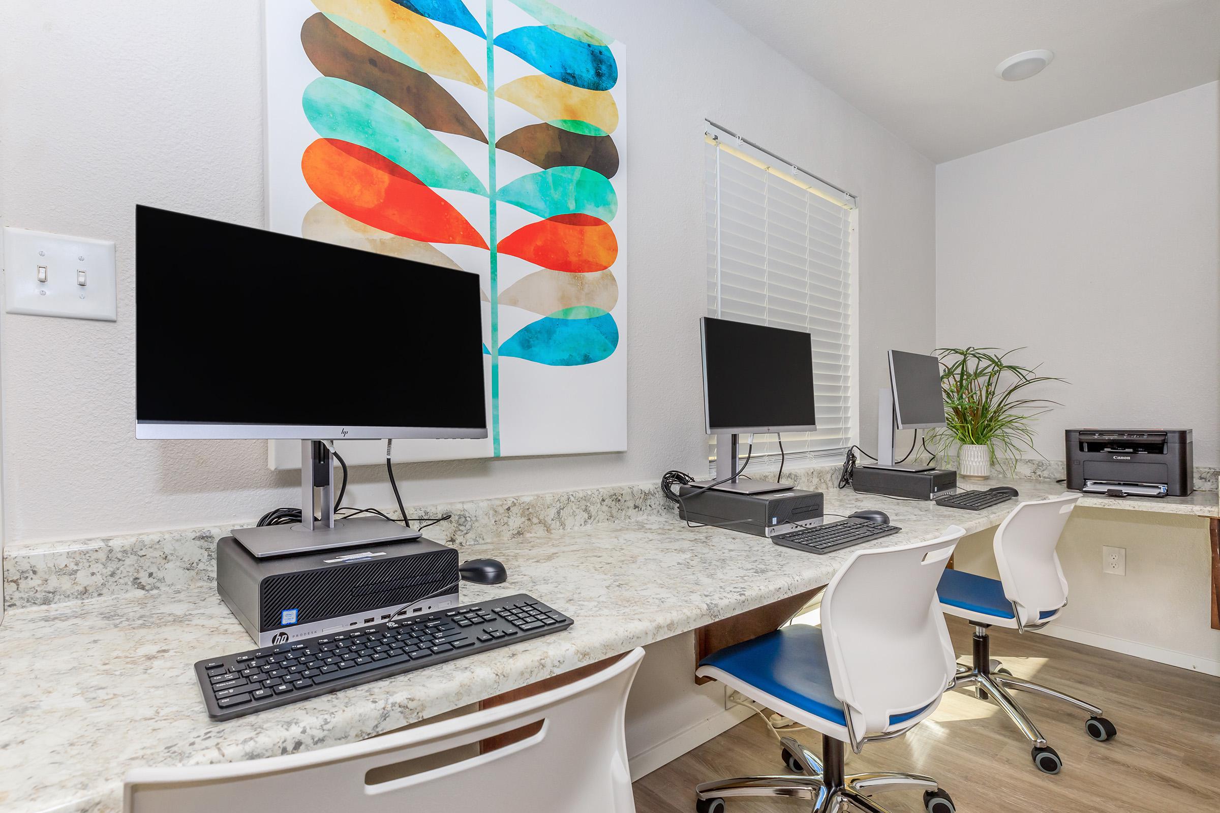 a desk with a computer and a chair in a room