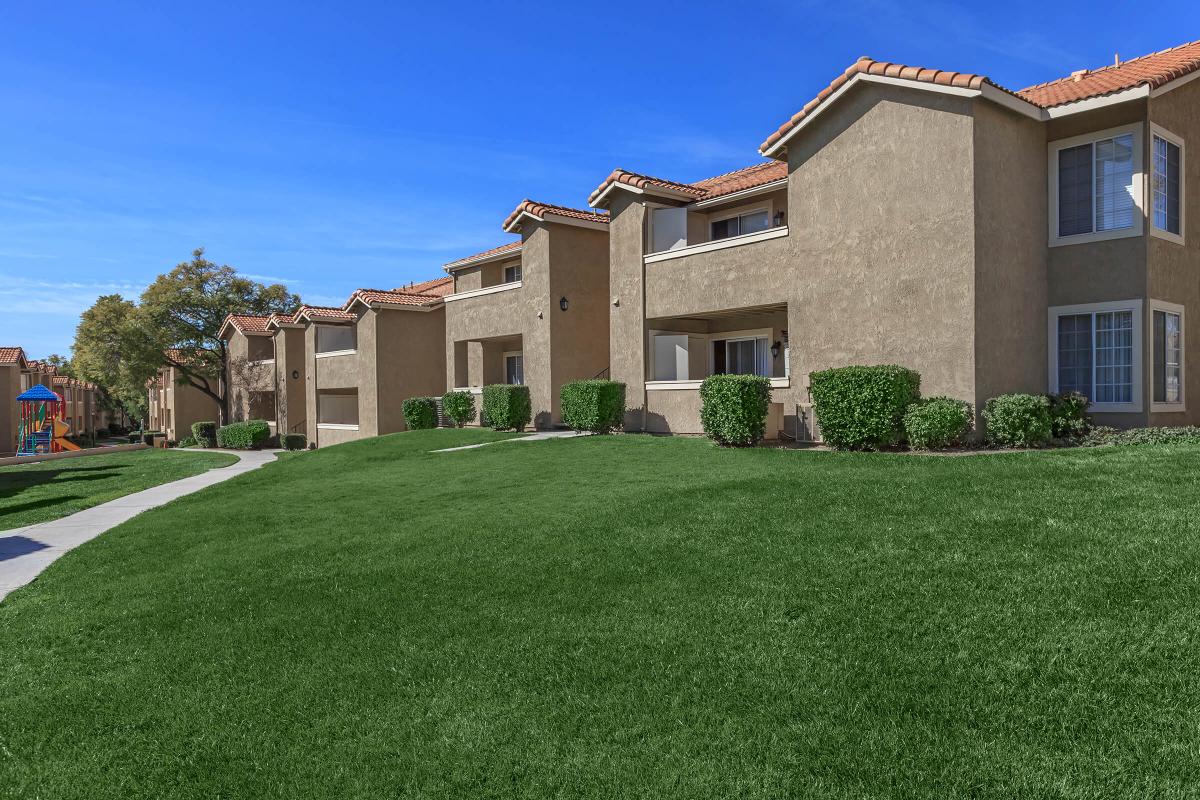 a large brick building with grass in front of a house