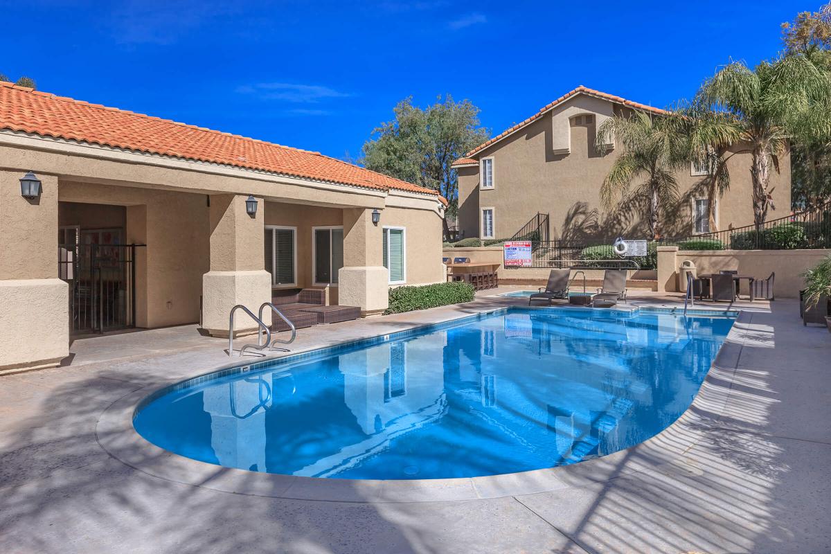 a blue and white house with a pool in front of a building