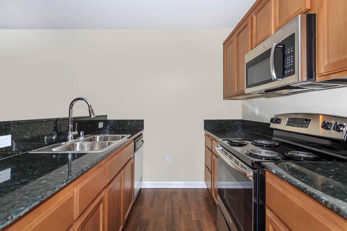 a modern kitchen with stainless steel appliances and wooden cabinets