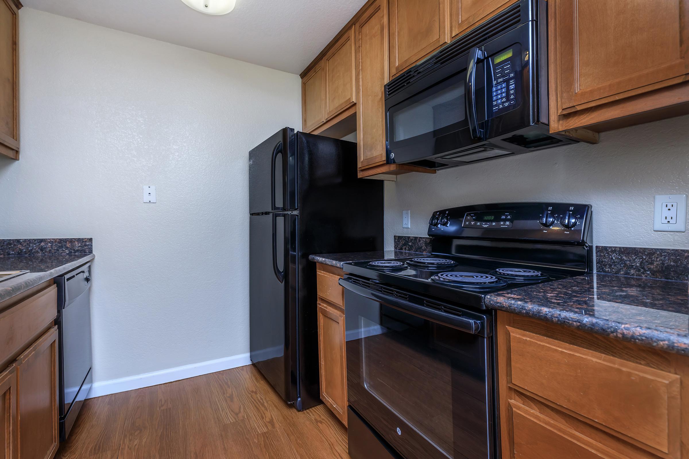 a modern kitchen with stainless steel appliances and wooden cabinets