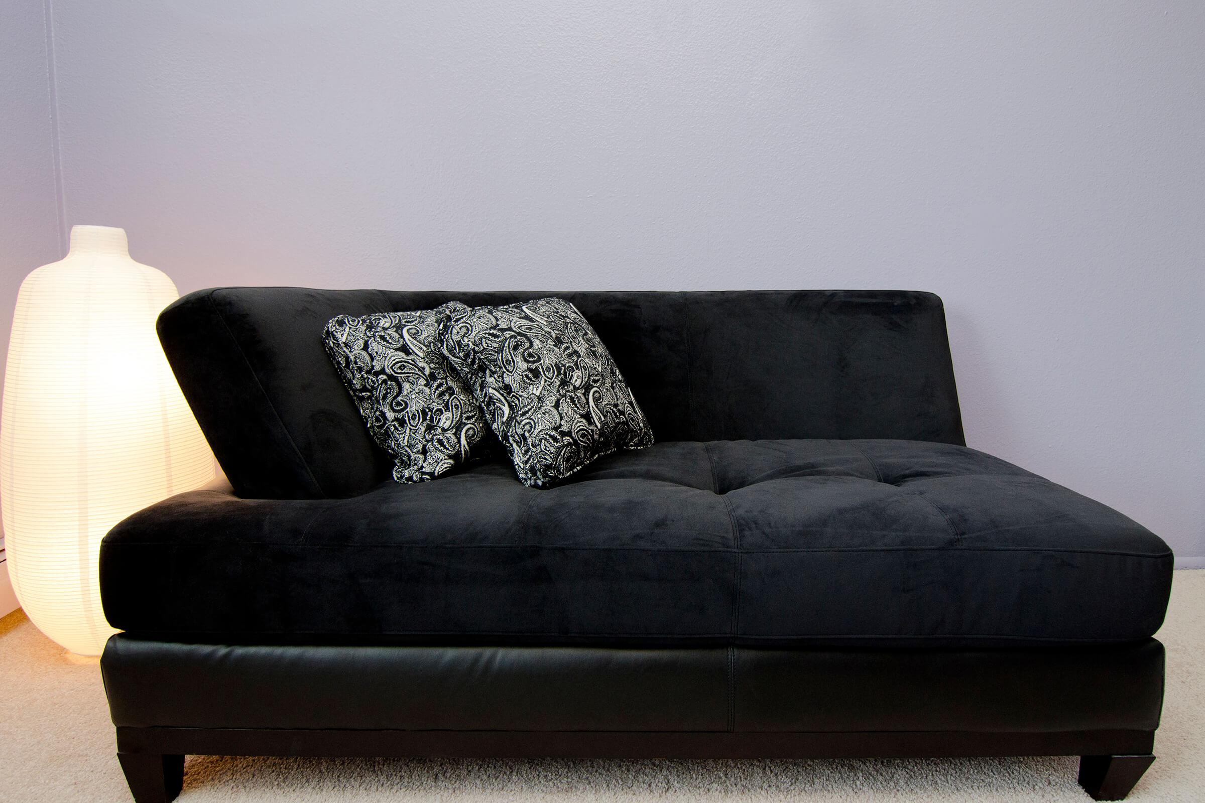 a living room with a black seat sitting in a chair