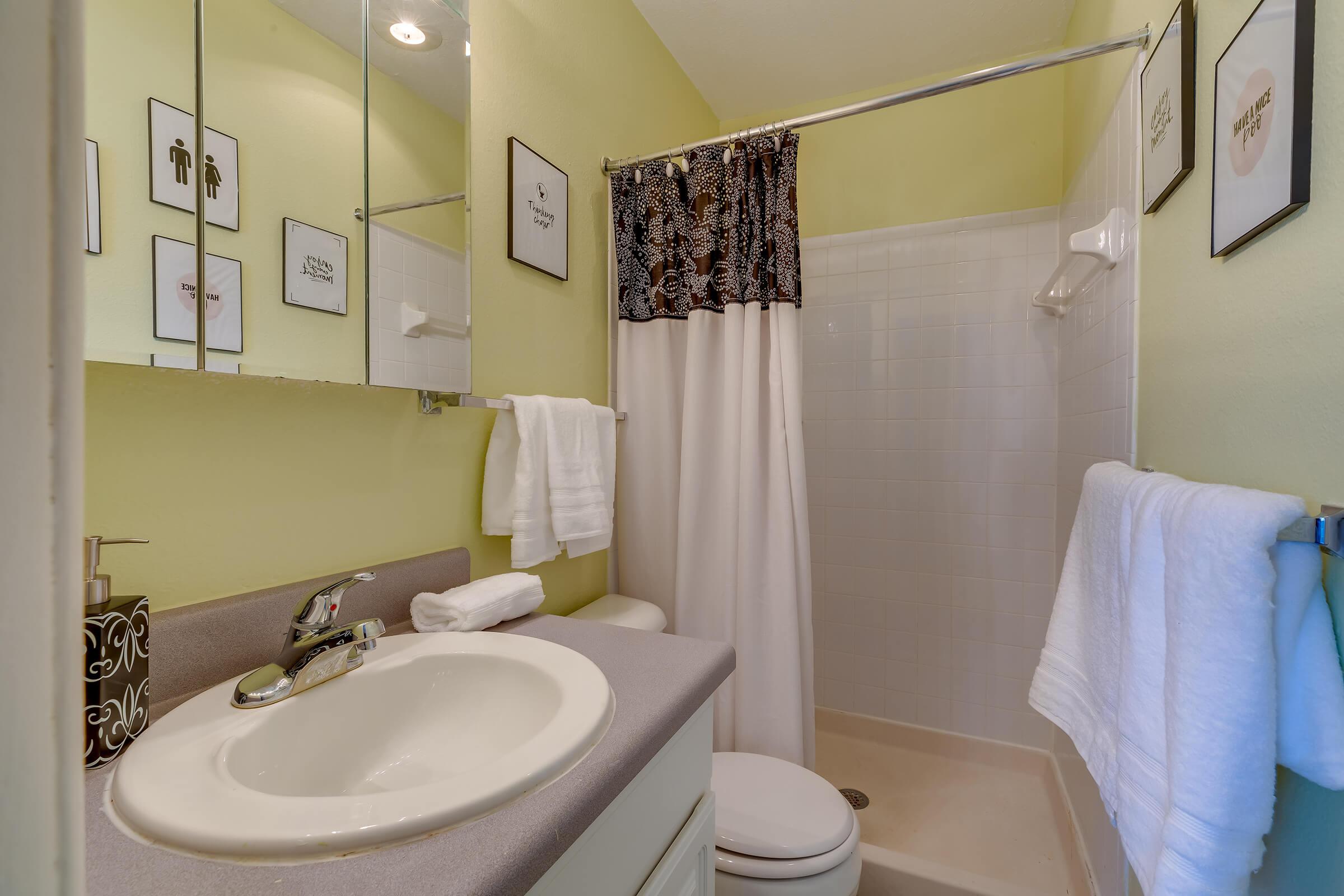 a white sink sitting under a mirror