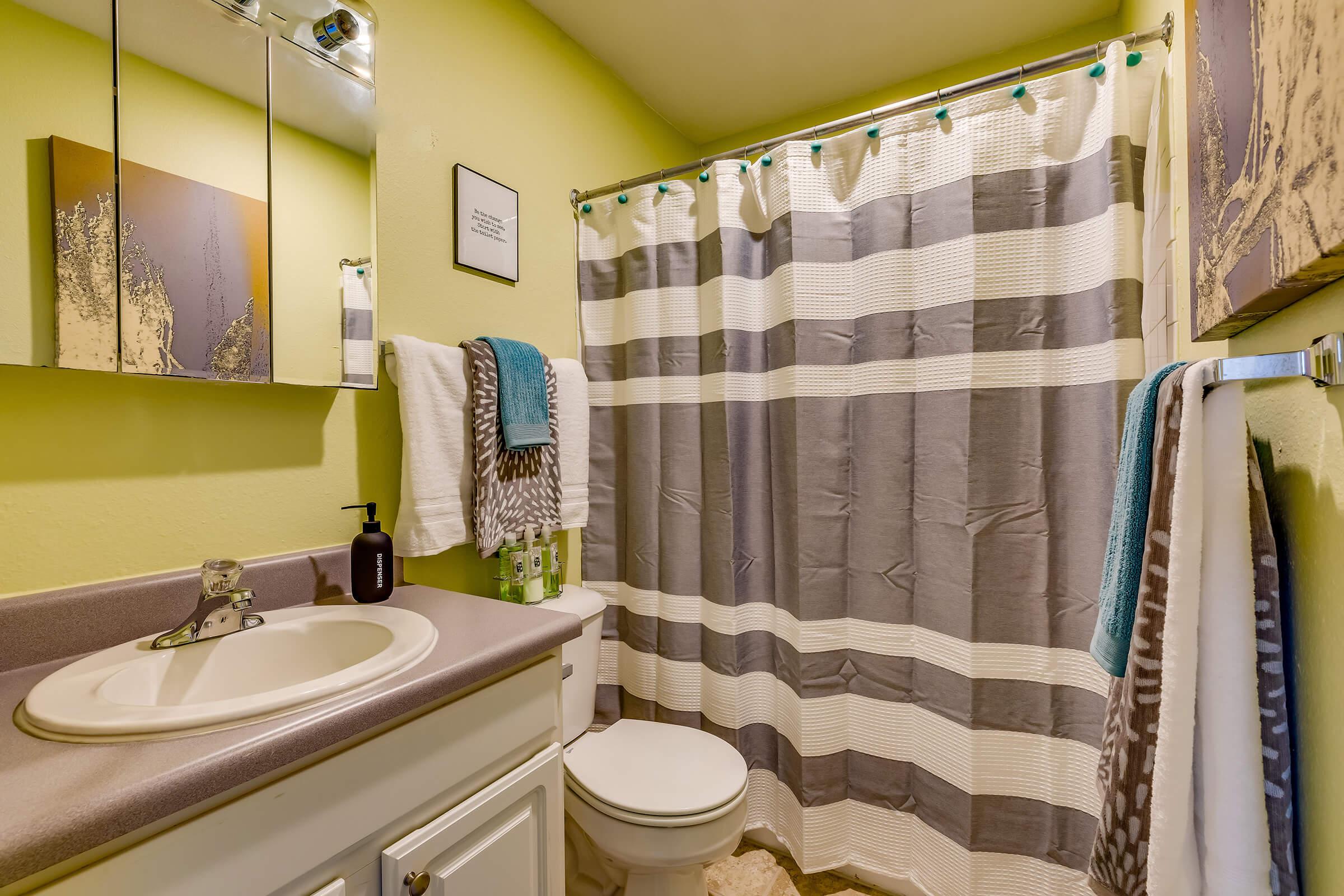 a white sink sitting next to a shower curtain