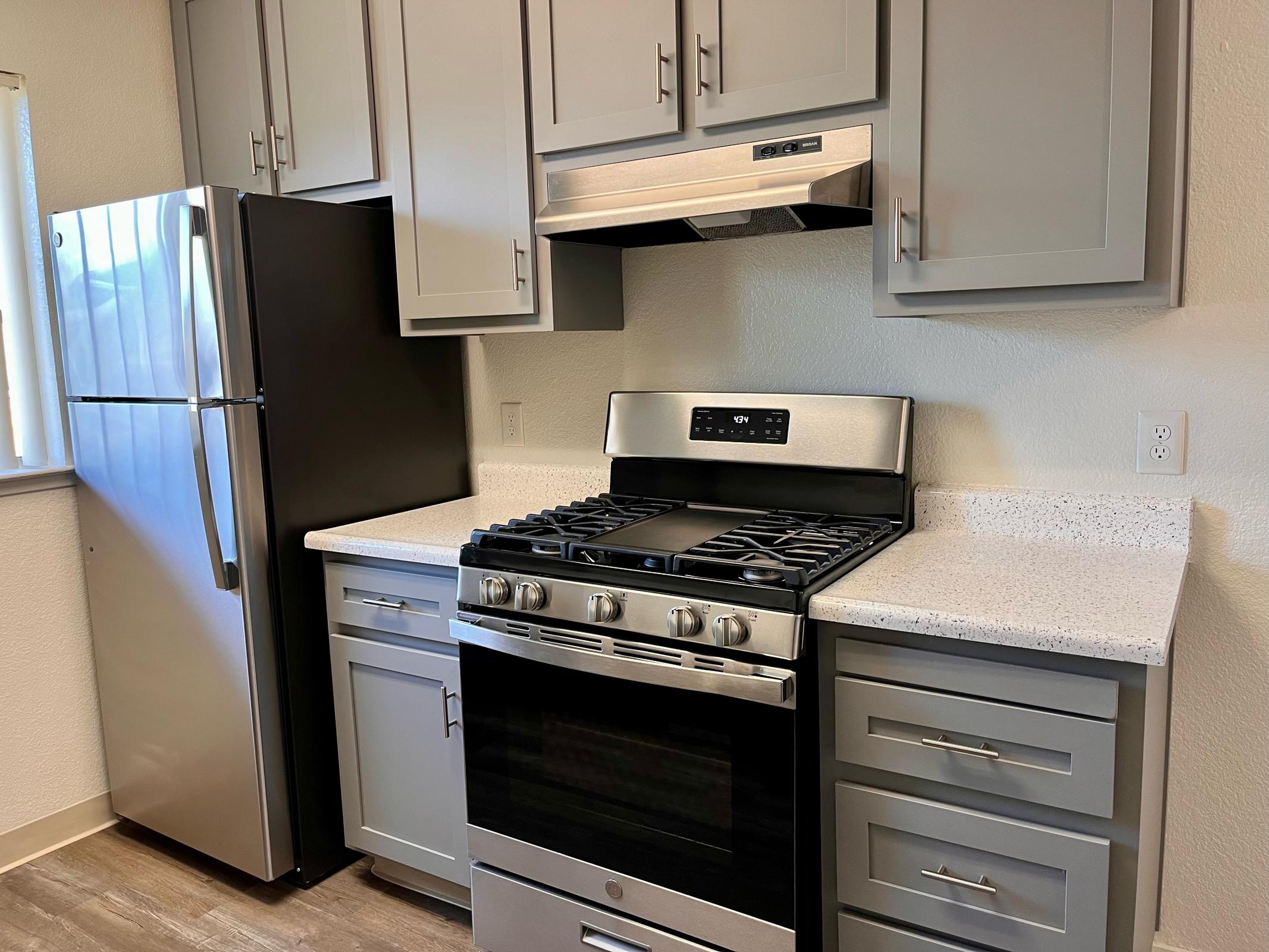 a stove top oven sitting inside of a kitchen