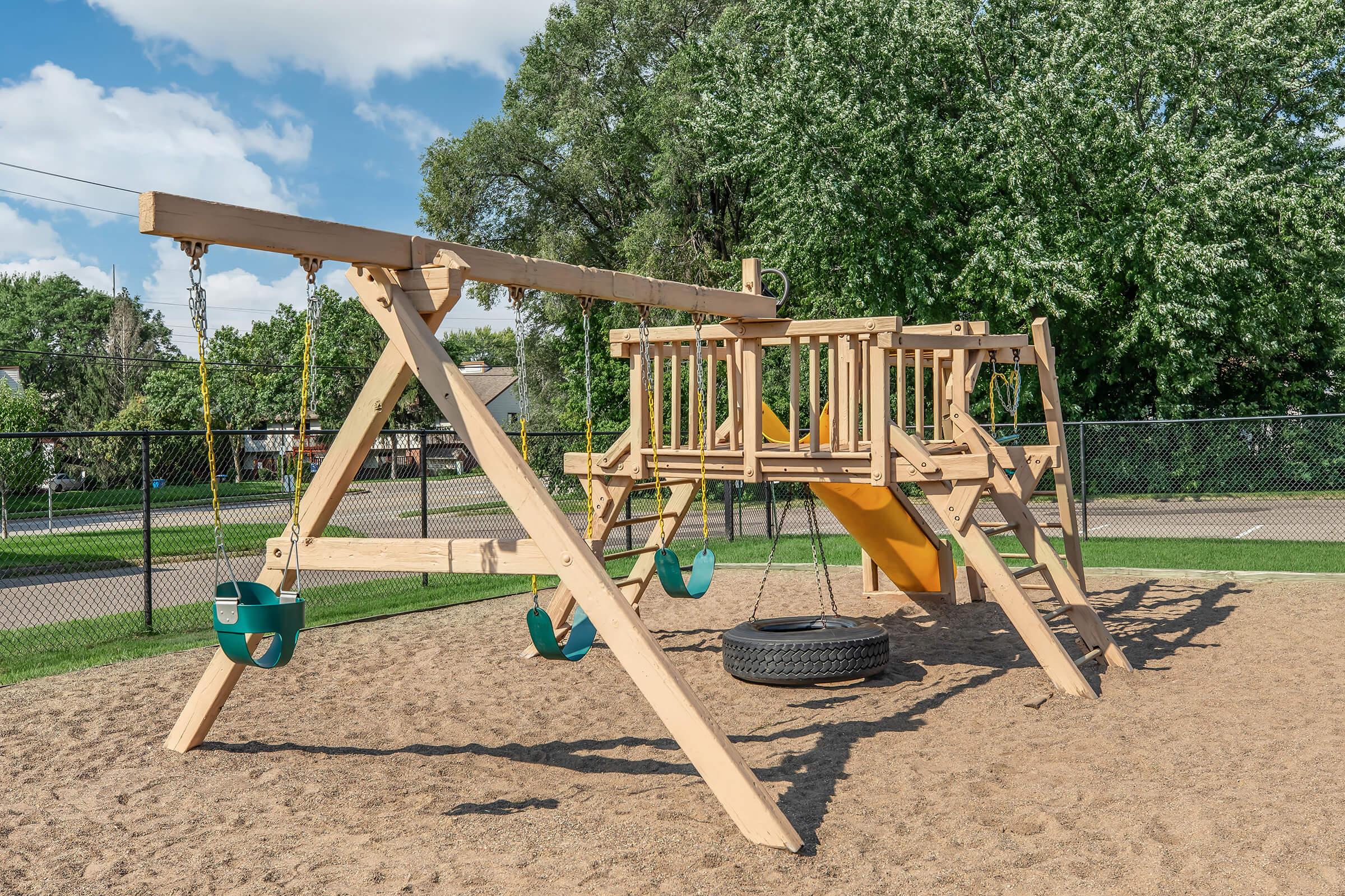 a wooden bench sitting in front of a playground