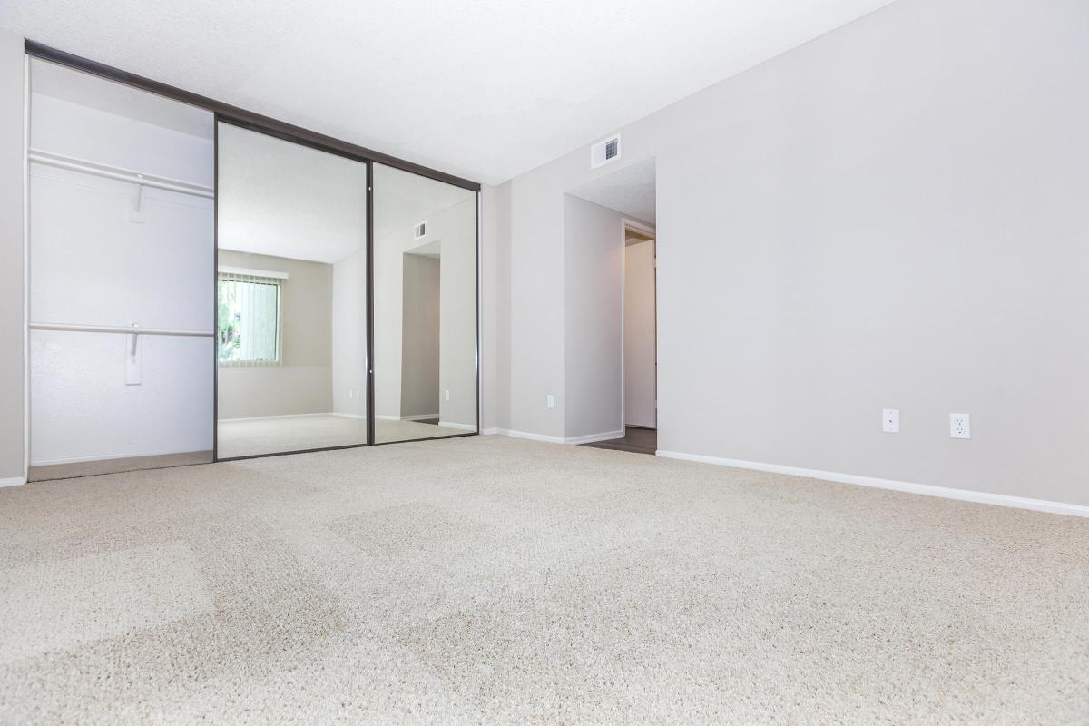 Bedroom with open sliding mirror glass closet doors