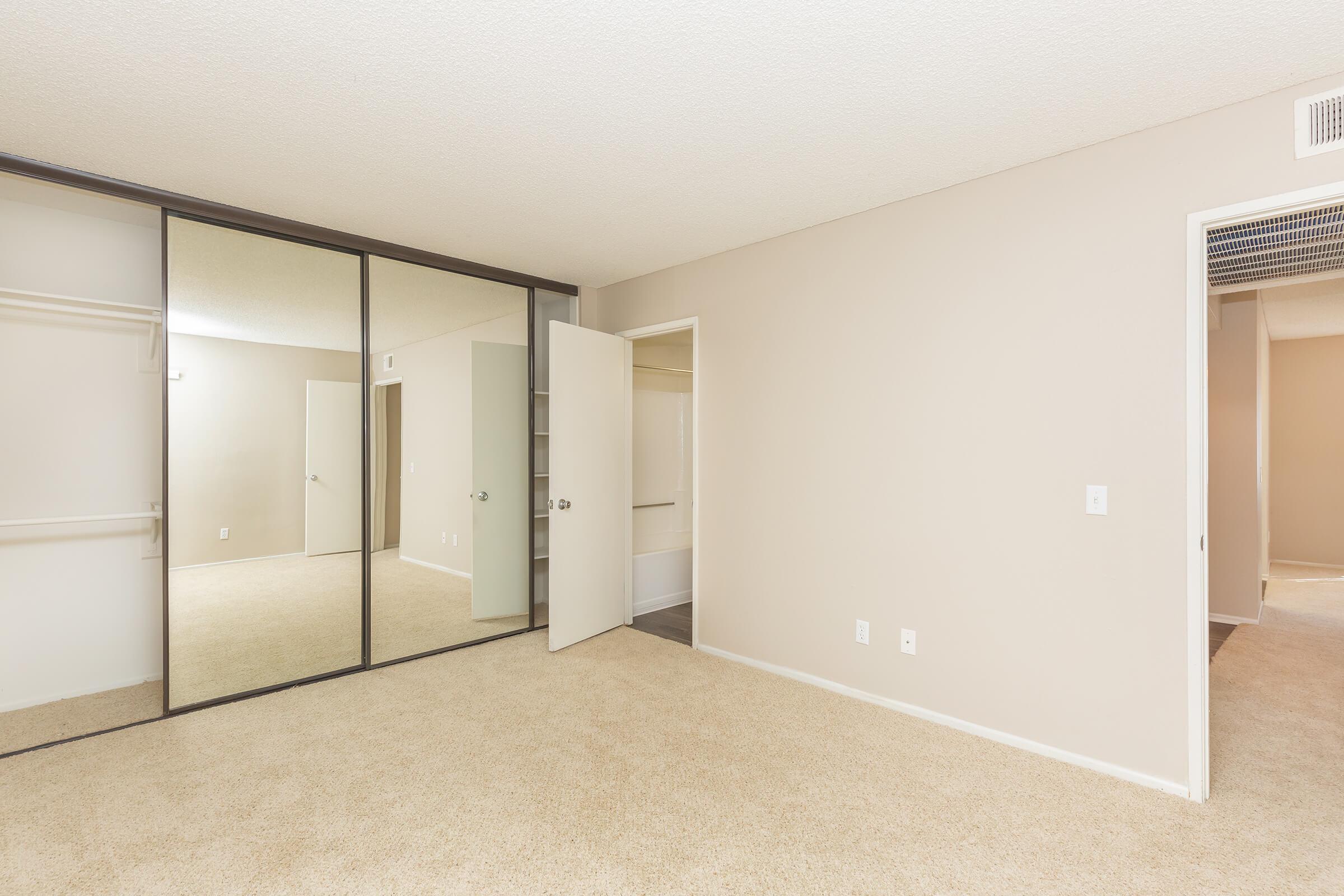 Unfurnished bedroom with open closet and bathroom doors