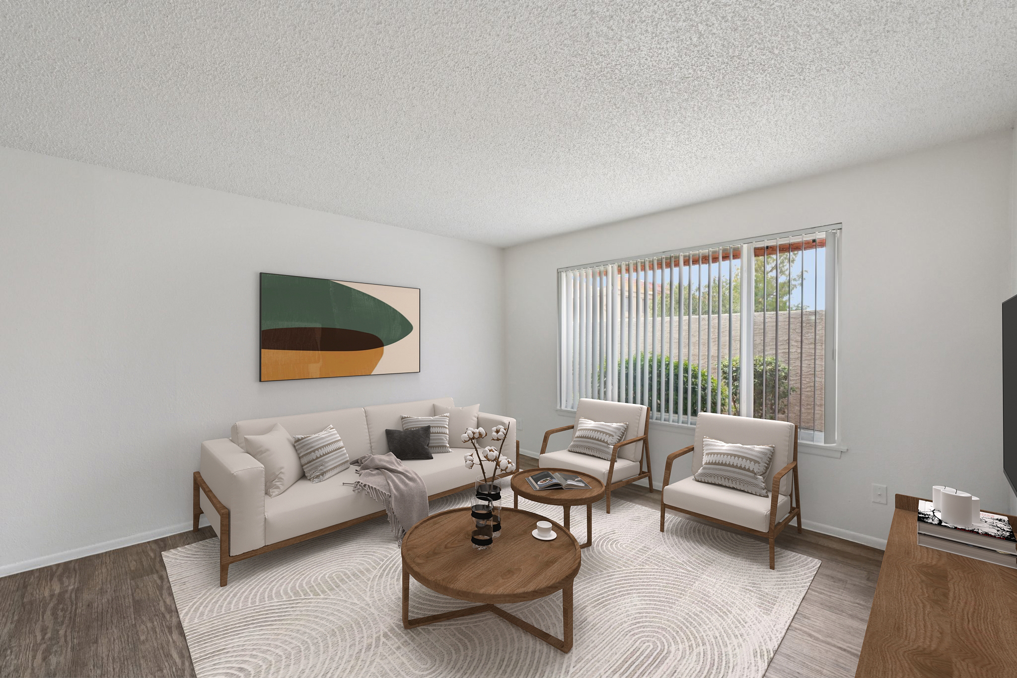 A modern living room featuring a light-colored sofa with decorative pillows, two armchairs, and a round coffee table. The space is accented by a large abstract painting on the wall and has a bright, airy feel with natural light coming through large windows adorned with white blinds.