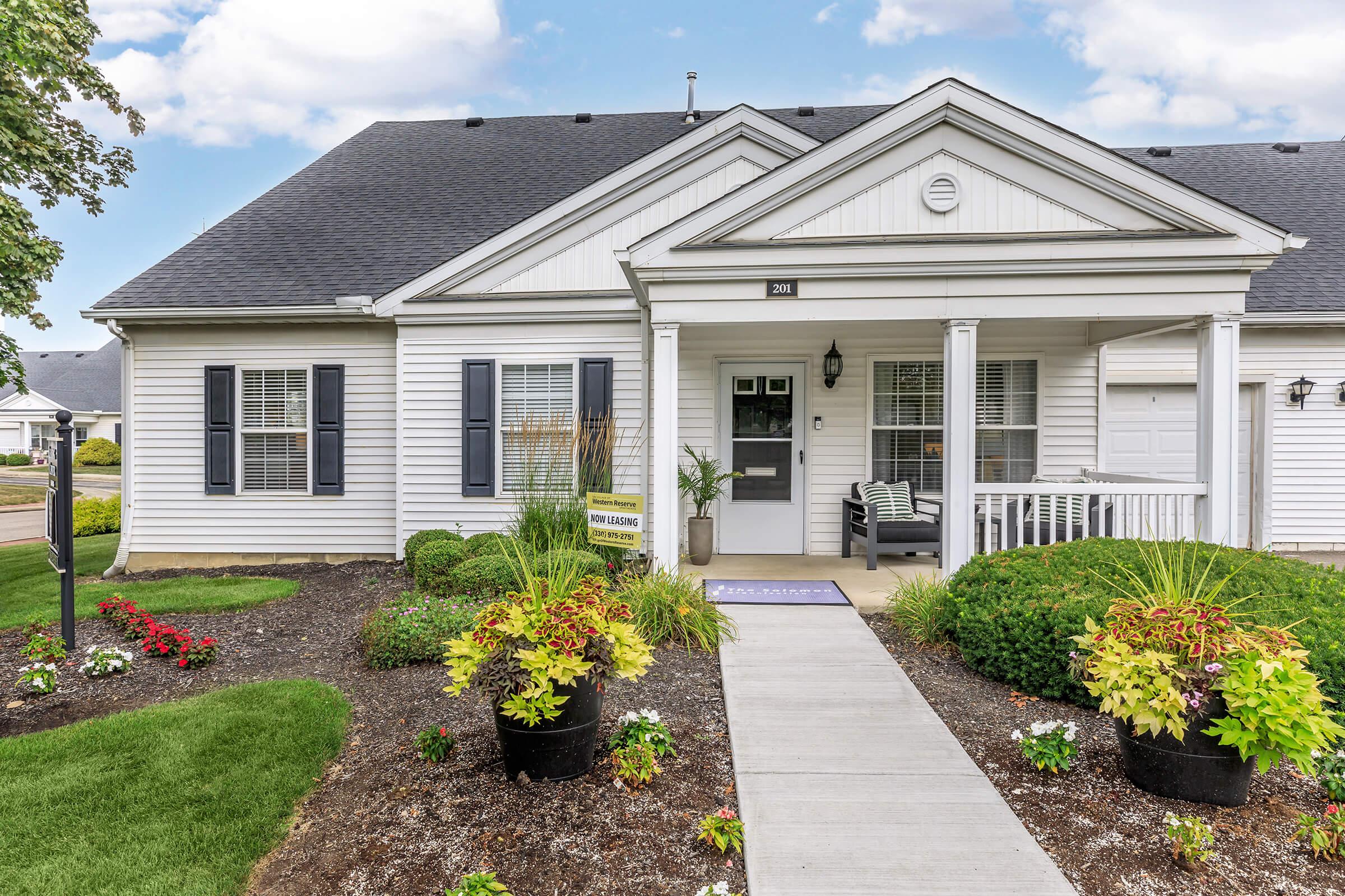 a close up of a flower garden in front of a house