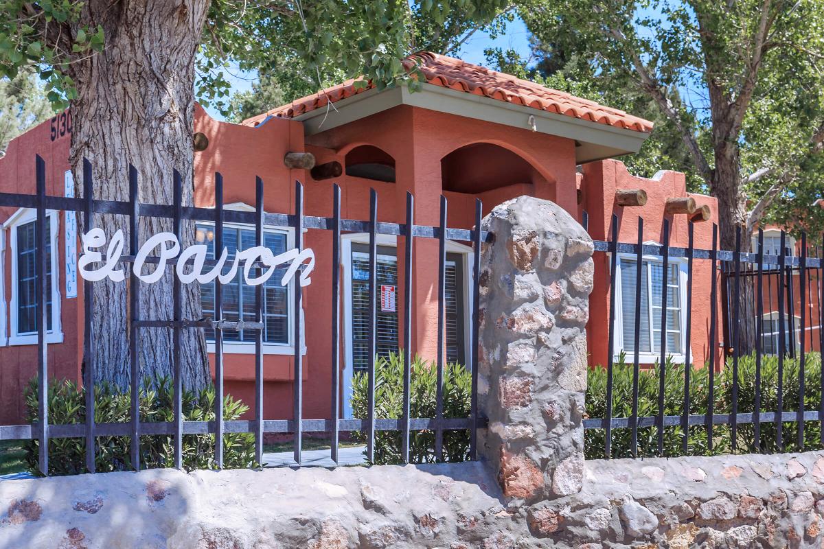 a house with a fence in front of a building