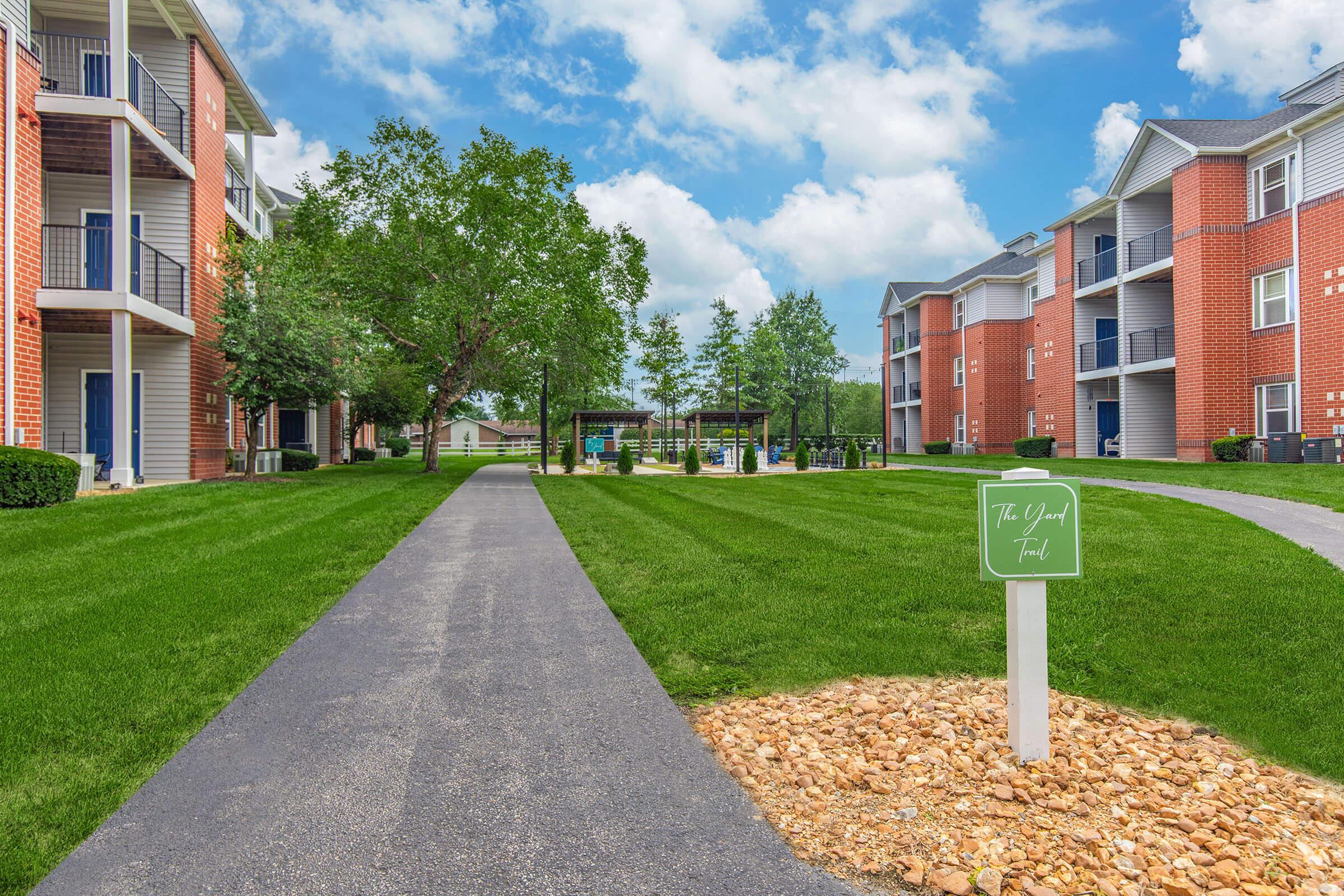 a house with a lawn in front of a brick building