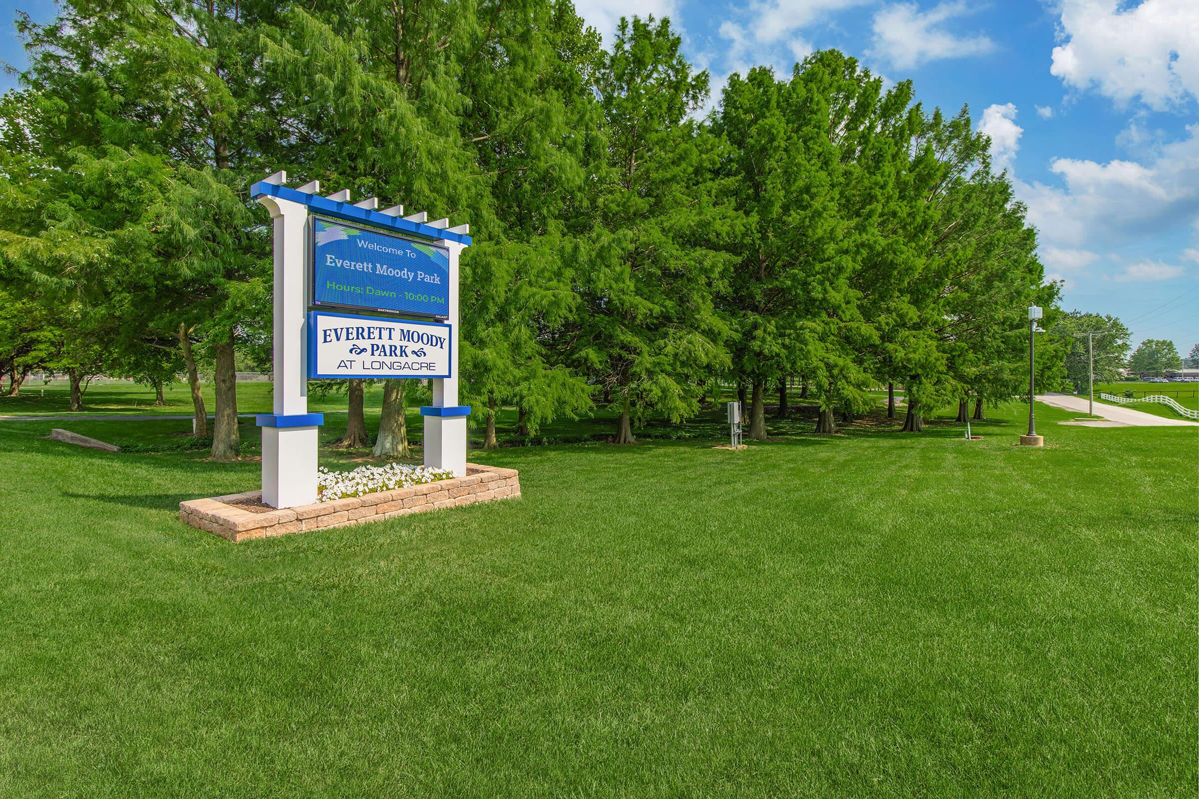 a sign in front of a green field