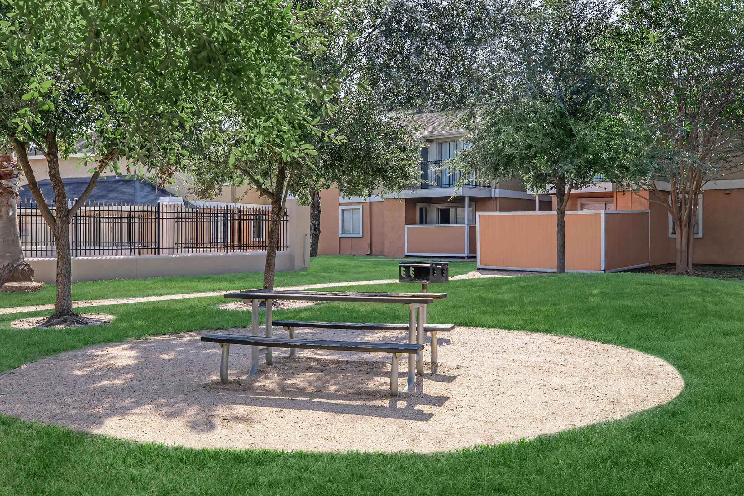 an empty park bench sitting in the grass