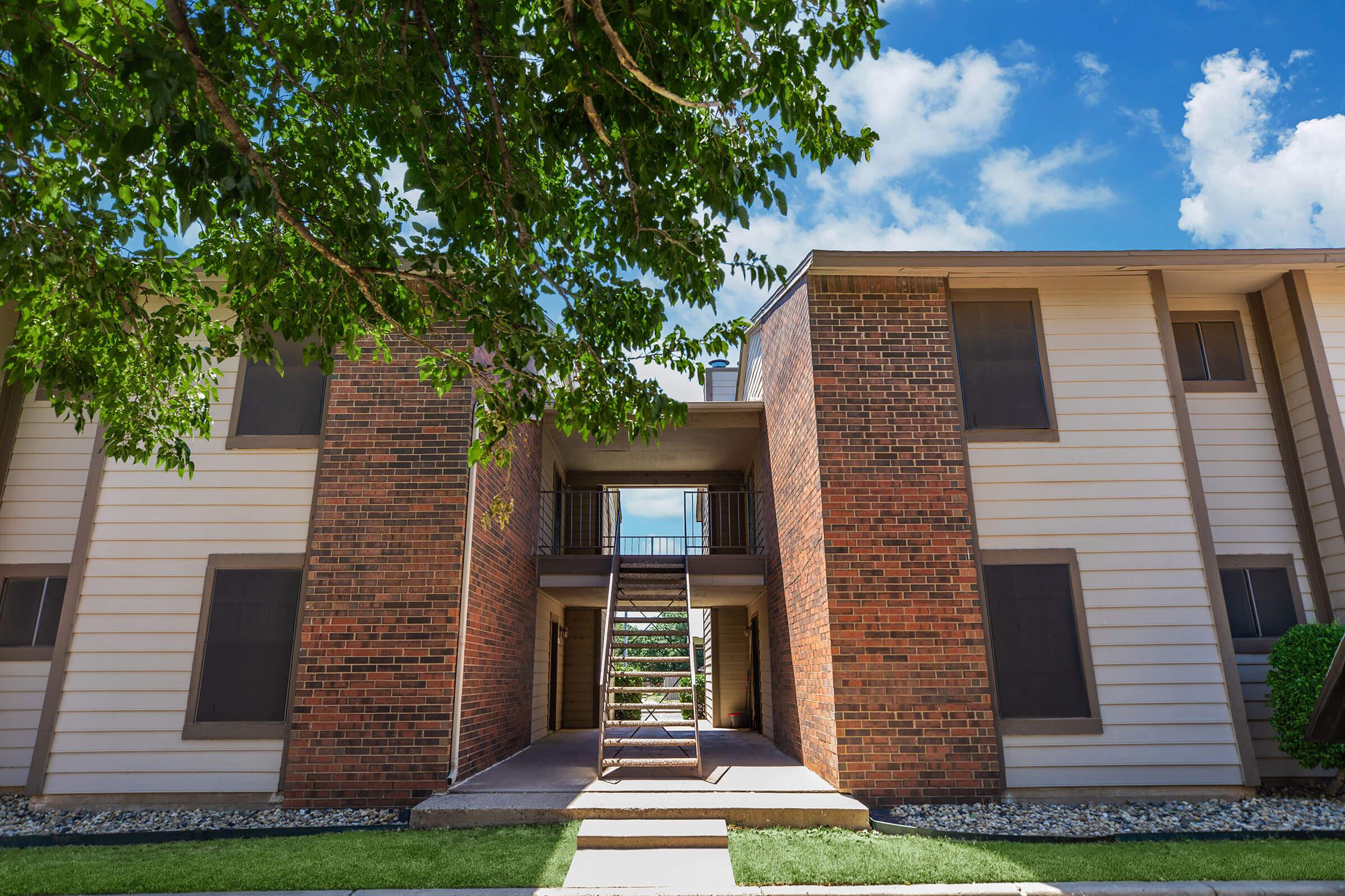 a large brick building with grass in front of a house