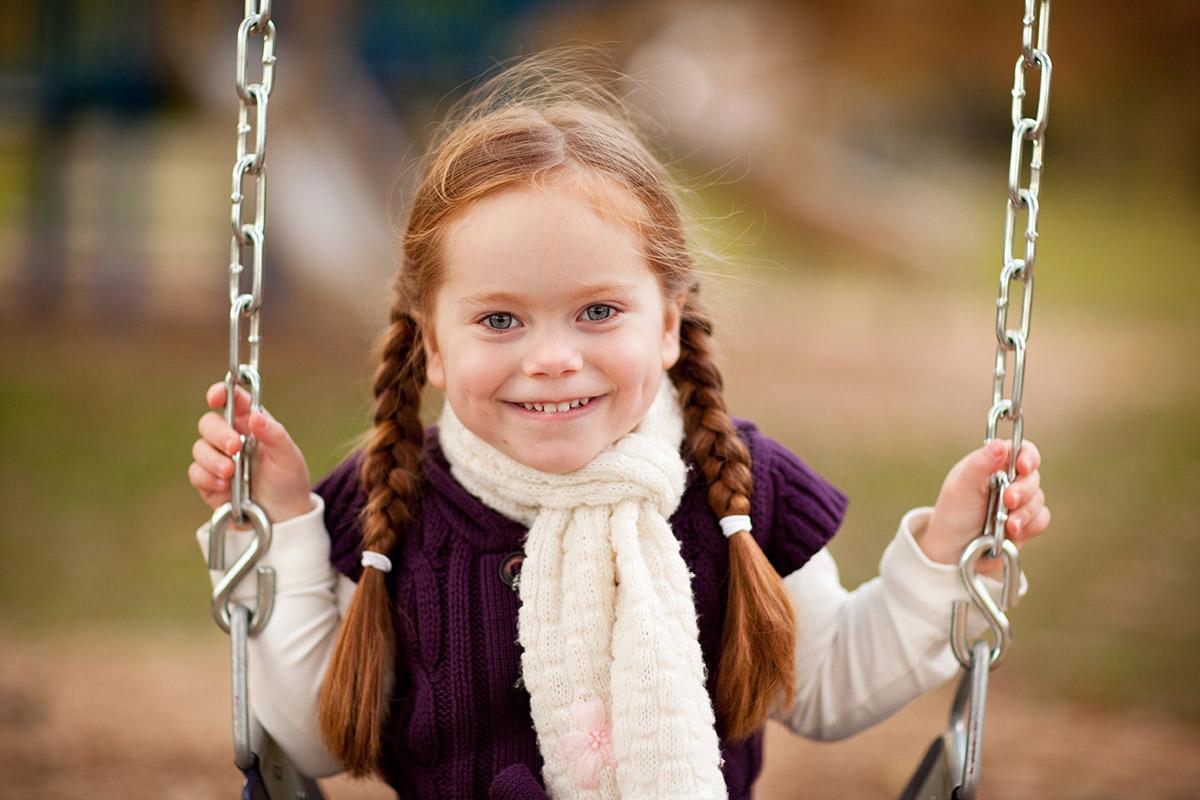 a girl is dressed in a swing